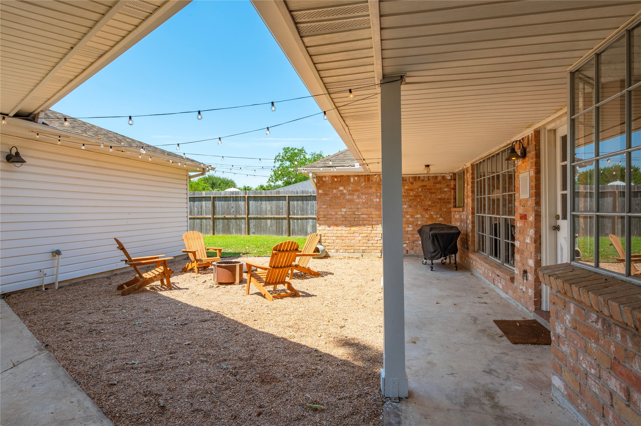 Great back patio area with covered concrete patio space and pebble courtyard.