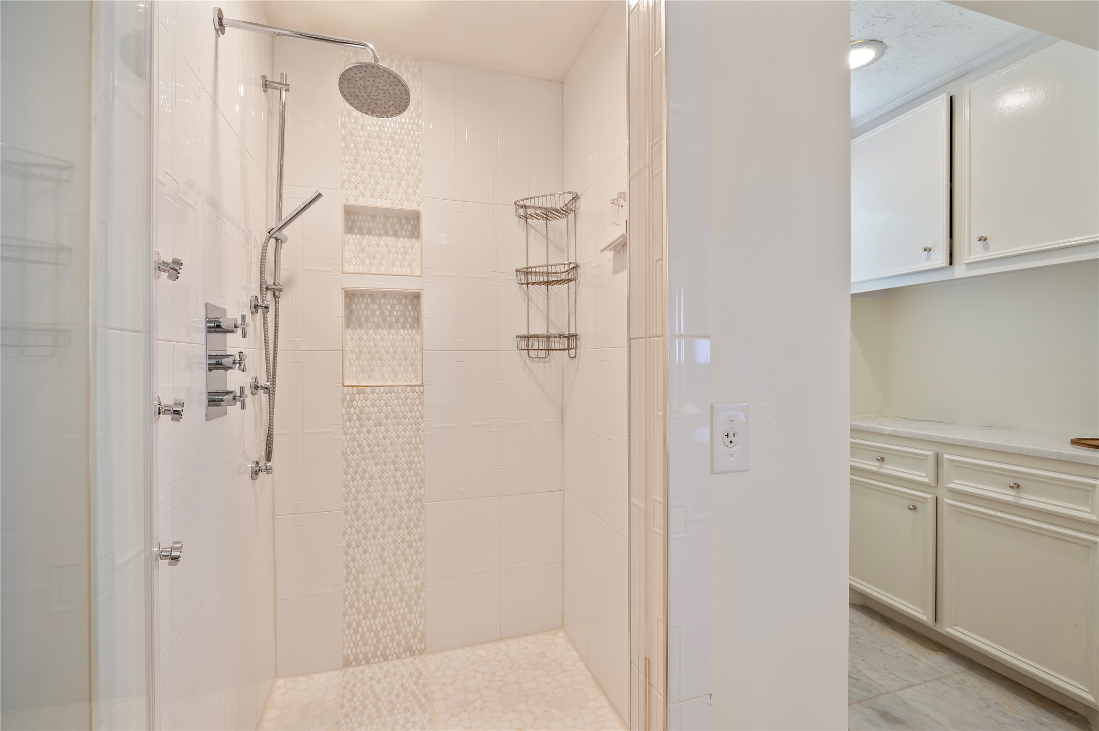Spacious walk in shower with tile surfacing.