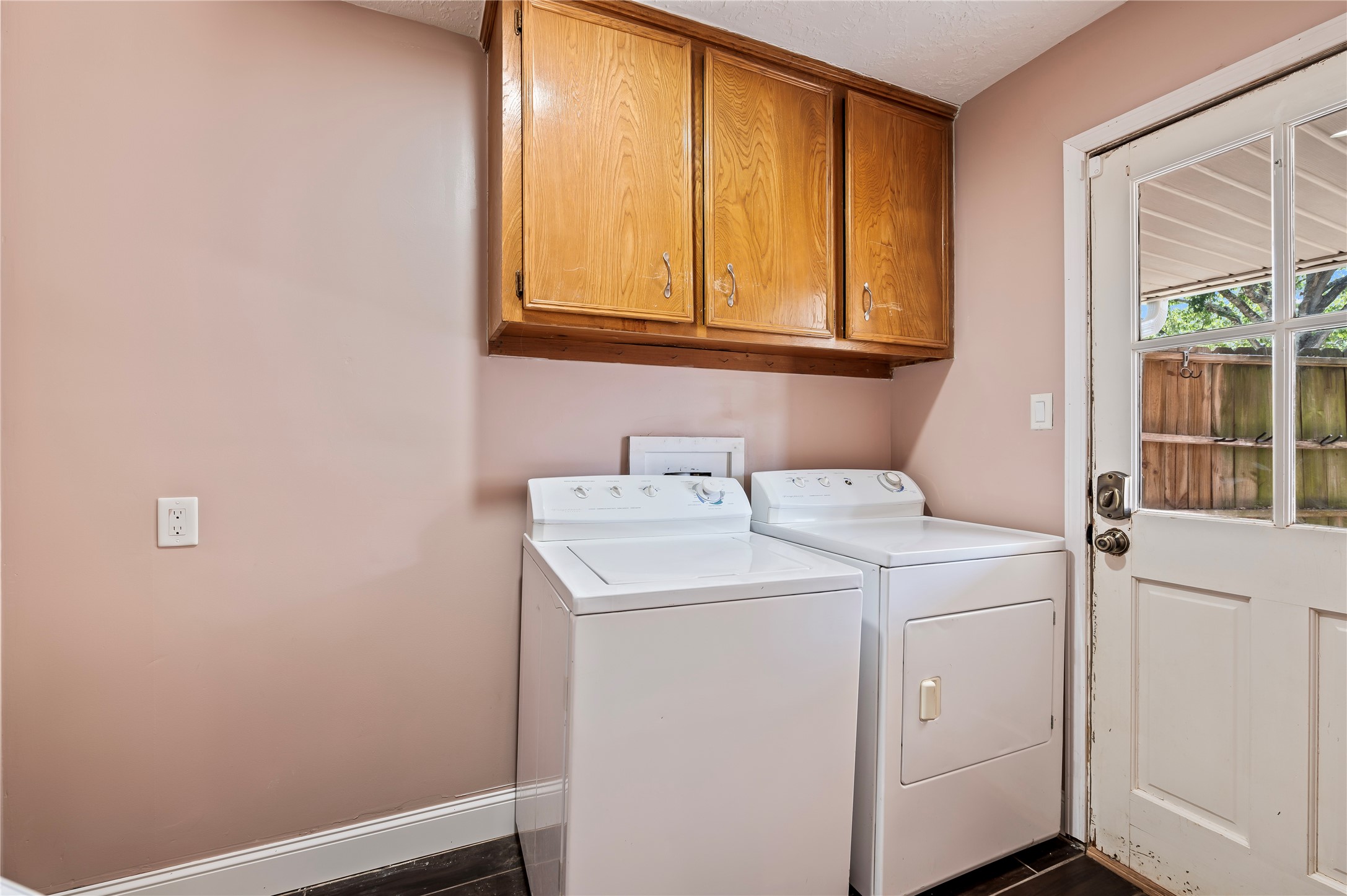 Utility room in house with space for additional refrigerator and built in cabinets.