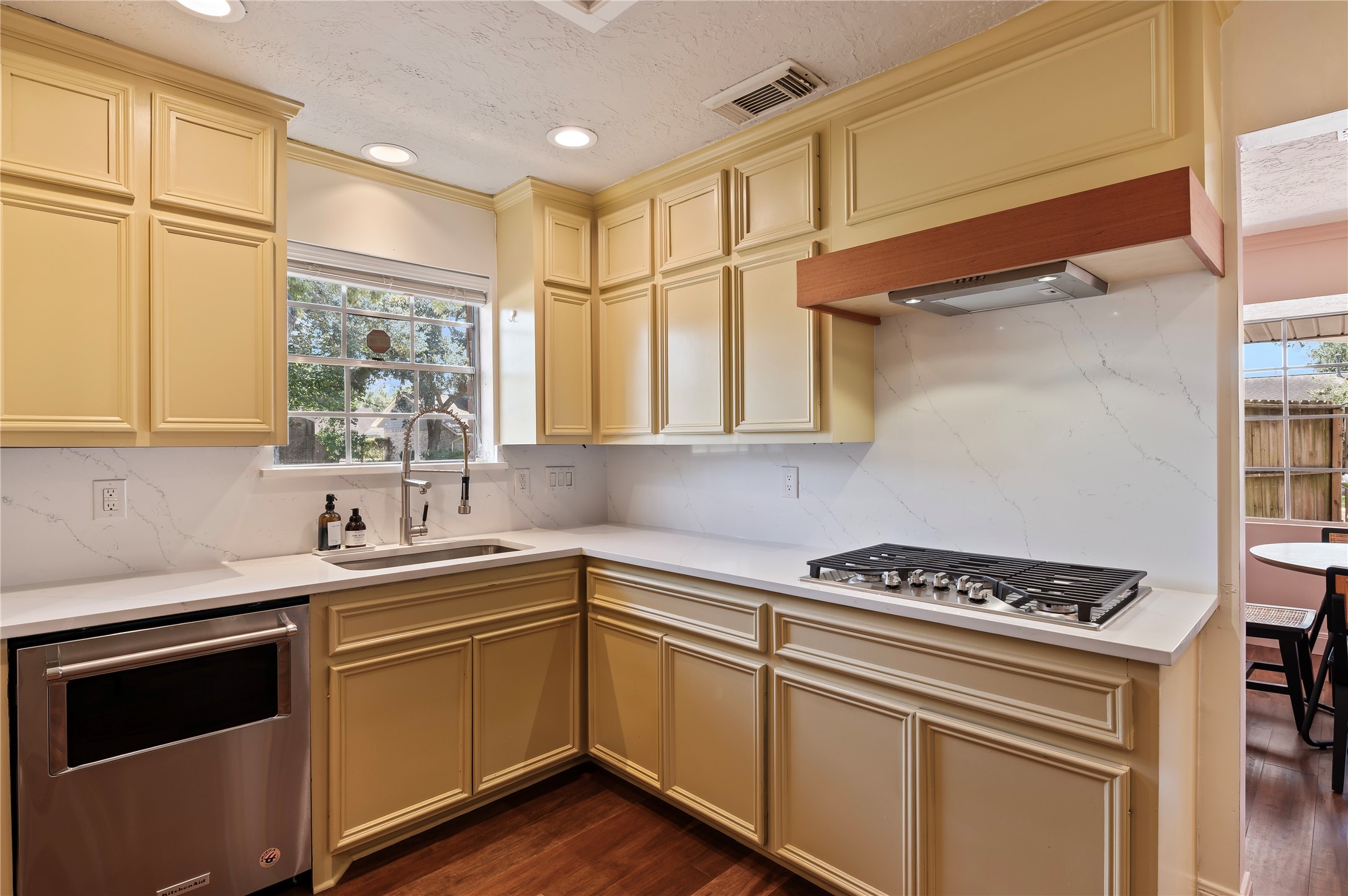 Built in gas range with overhead vent and light. Stainless steel sink with over the sink window and ample cabinet storage.