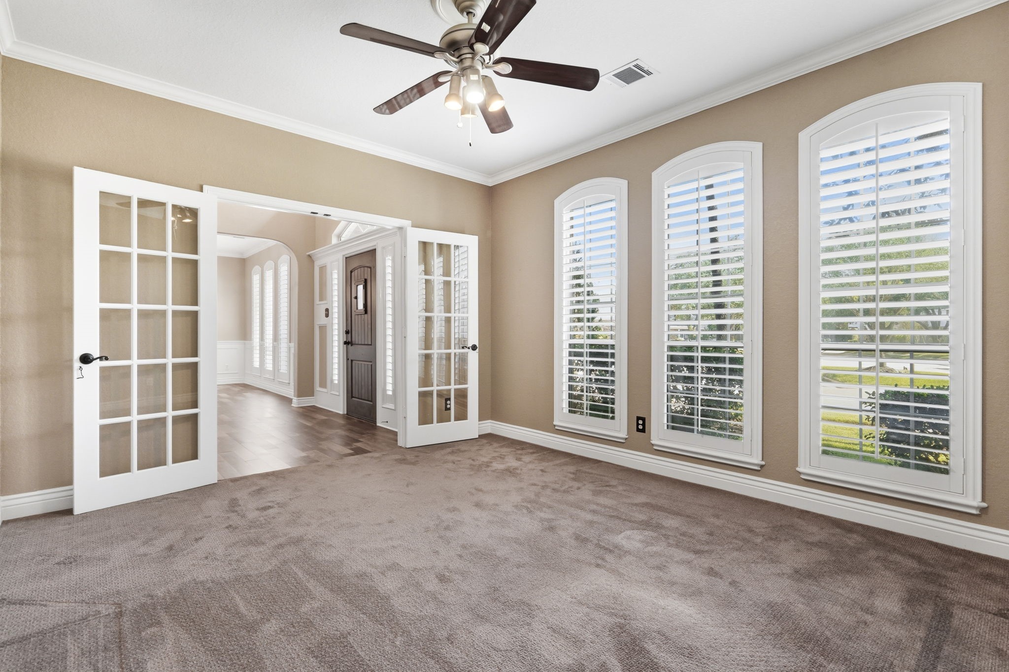 Office with French doors and custom shutters, offering a private workspace.