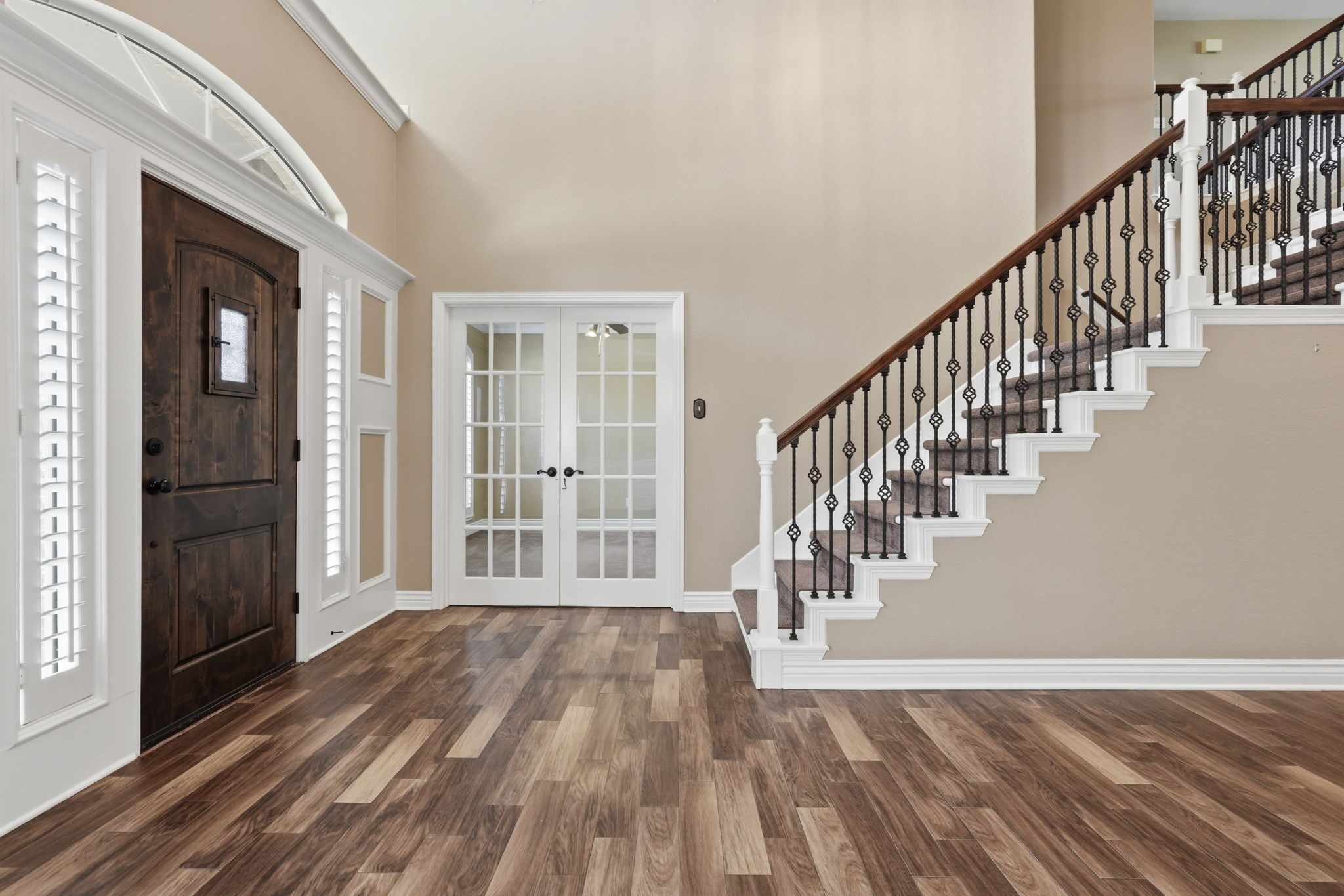 A welcoming entryway featuring an elegant wrought iron staircase. A welcoming entryway featuring an elegant wrought iron staircase.