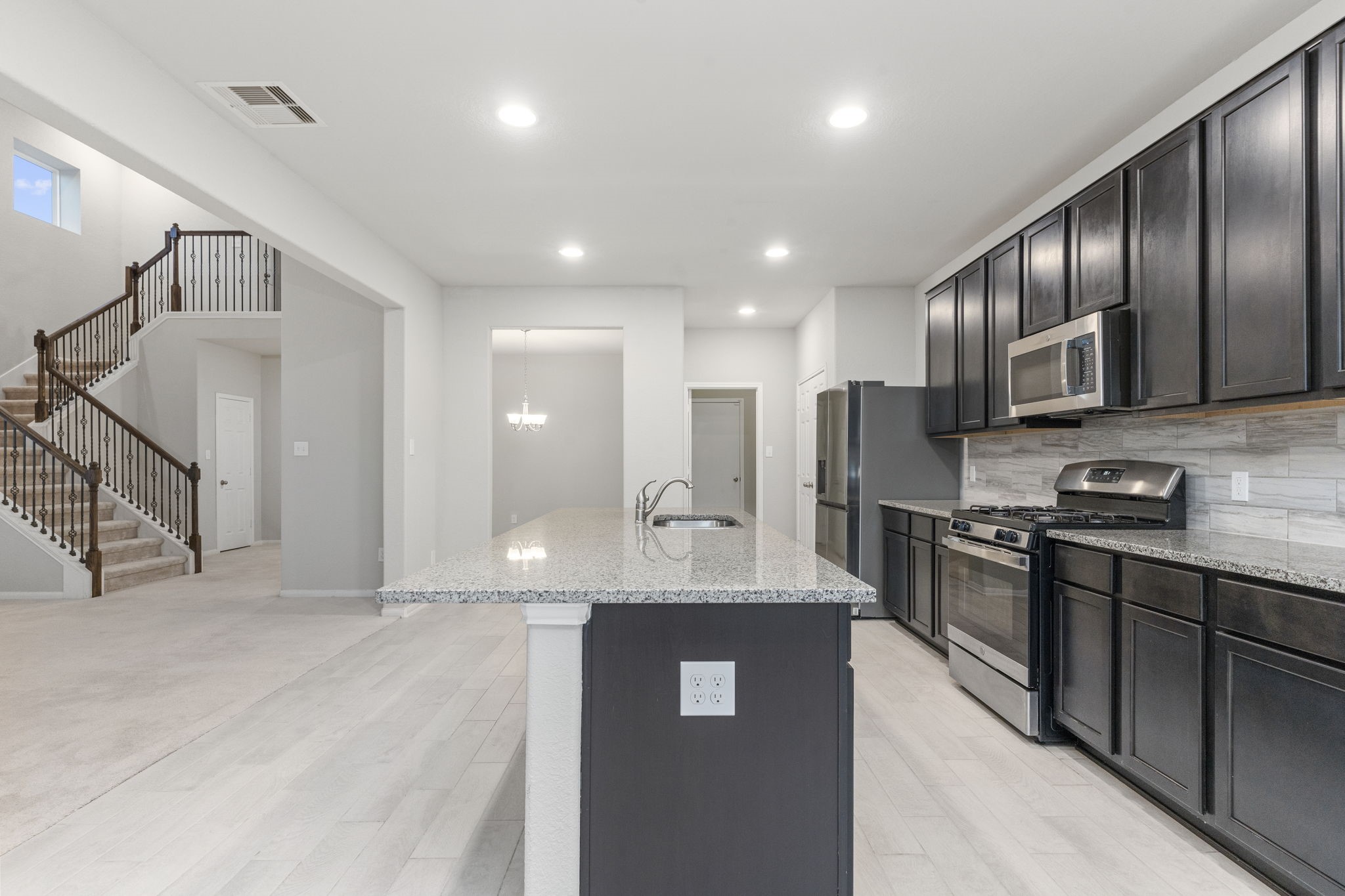 Rich dark wood cabinets adorn the Kitchen for ample storage