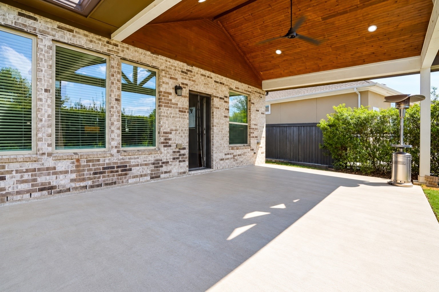 Spacious covered patio with ceiling fan and no back neighbors for added privacy.