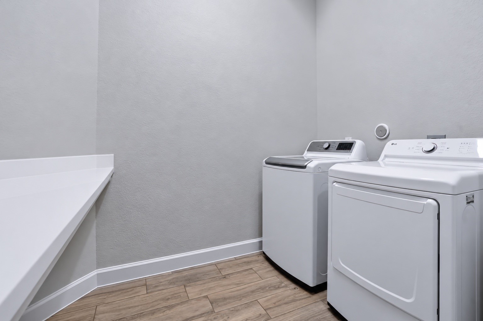 Dedicated laundry room with countertop space for folding and additional storage.