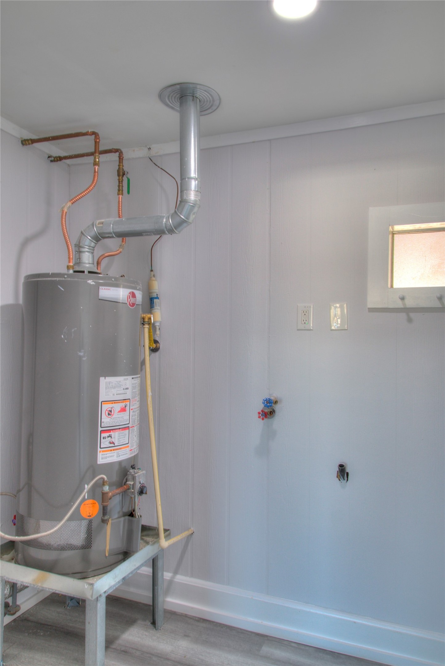 Convenient utility room with hookups for an electric washer and gas dryer.