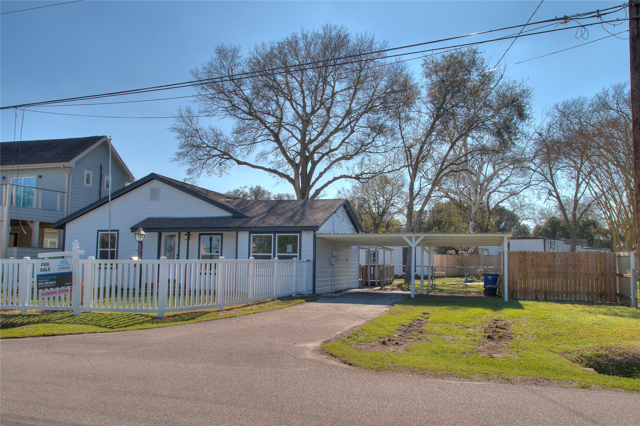 Front view of a charming single-story home featuring an attached two-car carport and additional RV parking space. Front view of a charming single-story home featuring an attached two-car carport and additional RV parking space.