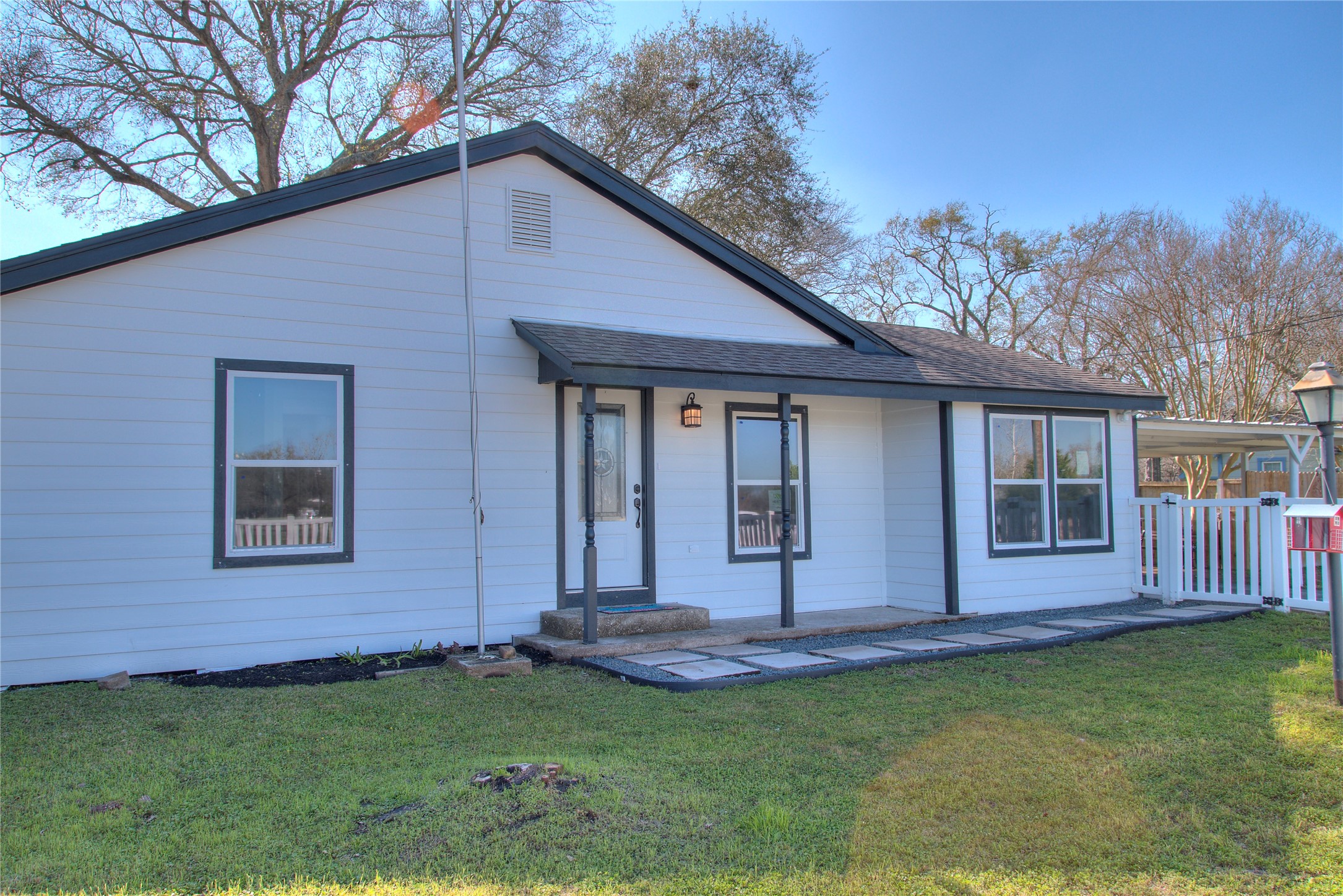 Charming front view with a welcoming covered porch and elegant stepping stones. Charming front view with a welcoming covered porch and elegant stepping stones.