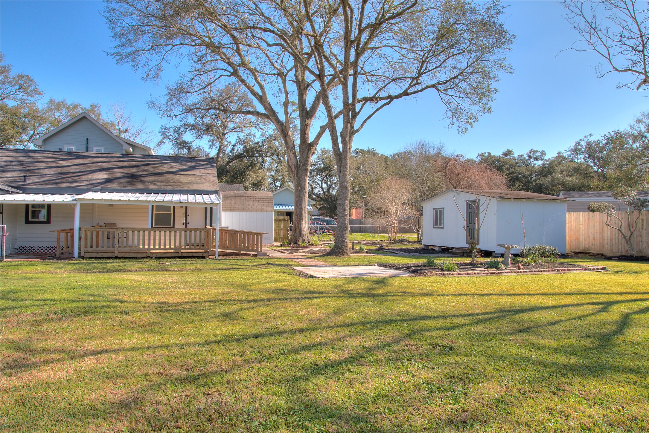 This charming property features a covered patio with decking and convenient ramp access, a storage shed, and a versatile shed with electricityperfect for a workshop or potential guest house conversion.