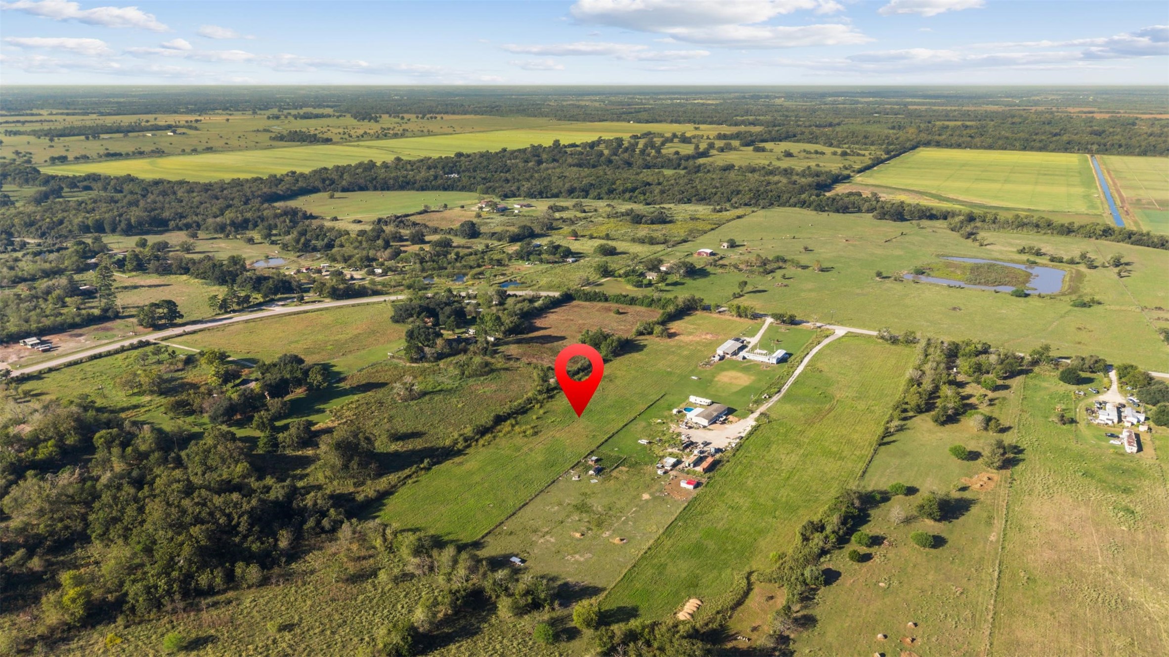 Southwest-facing aerial showcasing the property's location amid the rolling stretches of pastureland, wooded areas, and neighboring rural properties that define the Waller County countryside. Southwest-facing aerial showcasing the property's location amid the rolling stretches of pastureland, wooded areas, and neighboring rural properties that define the Waller County countryside.