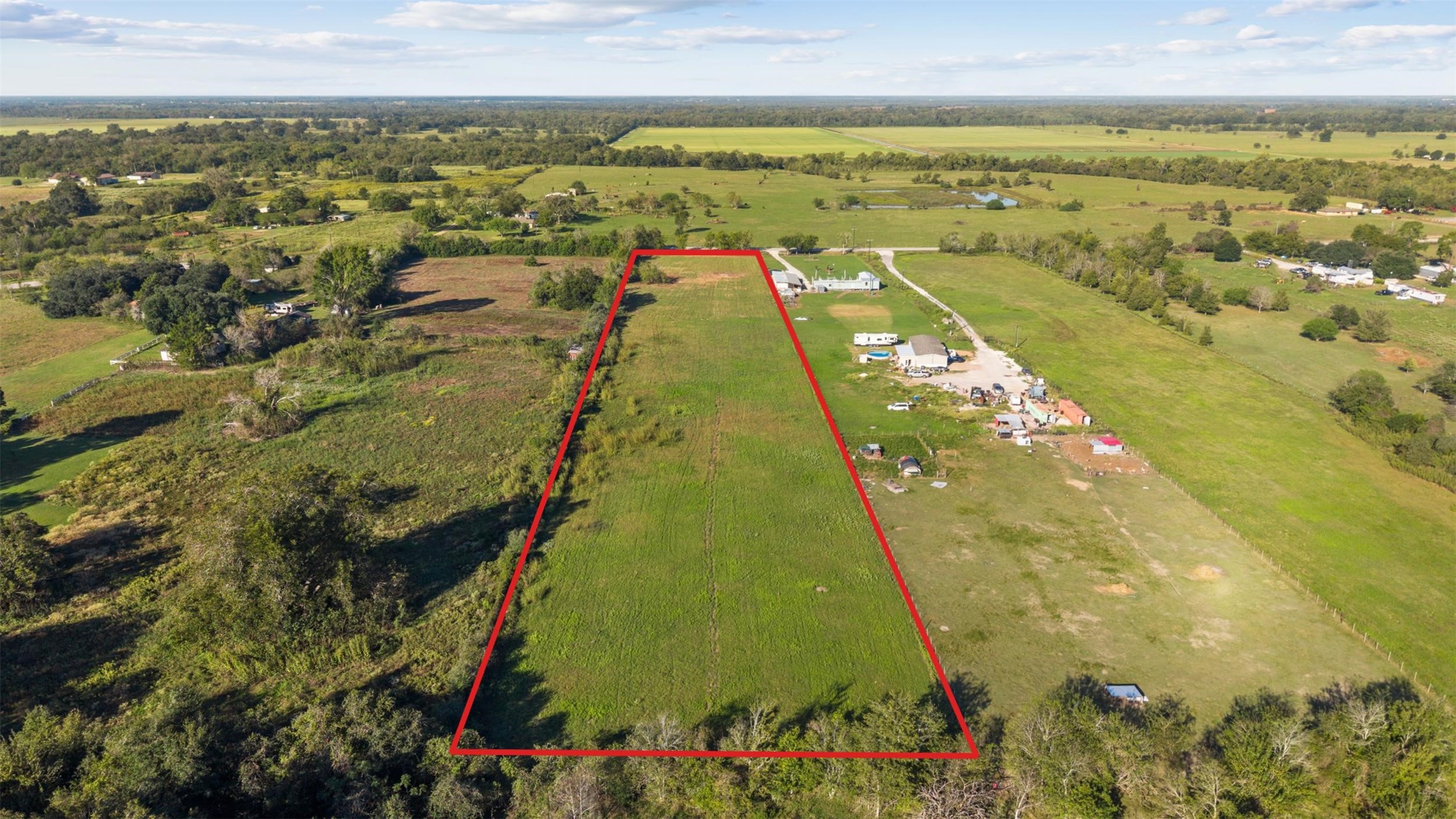 A west-facing aerial perspective highlighting the property's position among neighboring acreage tracts, open pastures, and the scenic countryside surrounding Hempstead. A west-facing aerial perspective highlighting the property's position among neighboring acreage tracts, open pastures, and the scenic countryside surrounding Hempstead.