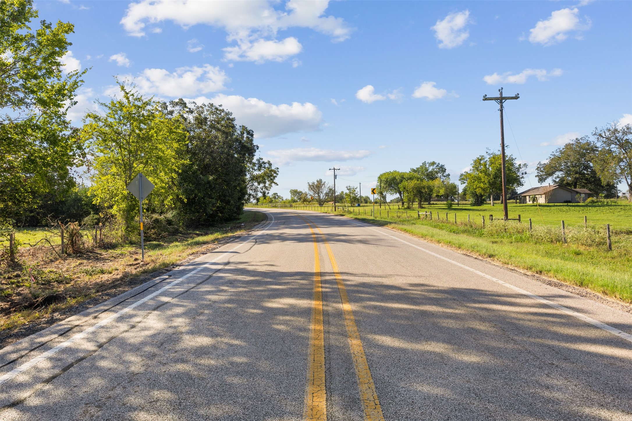 Traveling south along FM 1887, with the property situated on the left, showcasing its paved road frontage and the surrounding rural landscape of Waller County. Traveling south along FM 1887, with the property situated on the left, showcasing its paved road frontage and the surrounding rural landscape of Waller County.