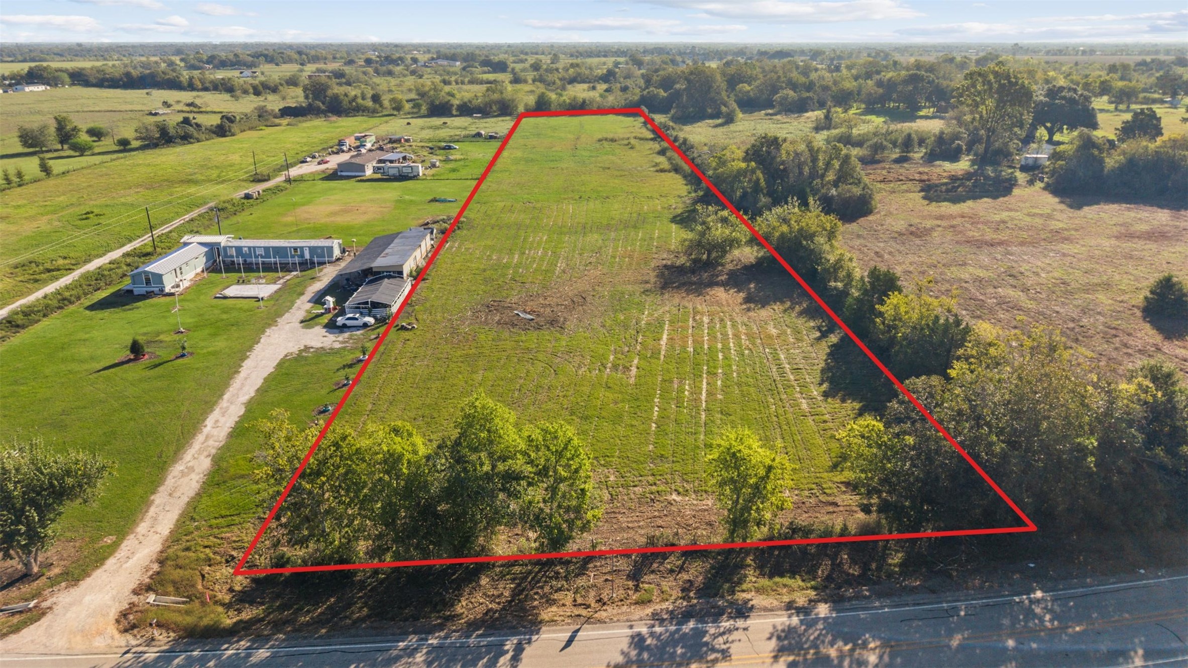 Aerial view facing east, showcasing the property's approximate boundaries, generous road frontage, and the surrounding countryside of Waller County. Aerial view facing east, showcasing the property's approximate boundaries, generous road frontage, and the surrounding countryside of Waller County.