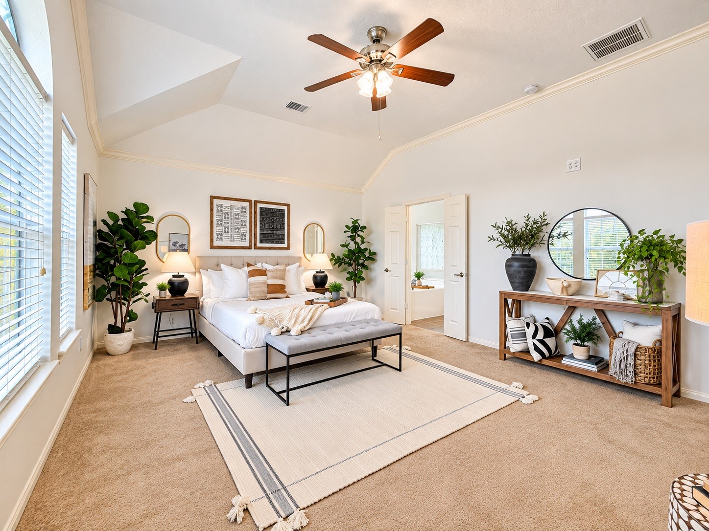Spacious and serene primary bedroom with abundant natural light and elegant decor.