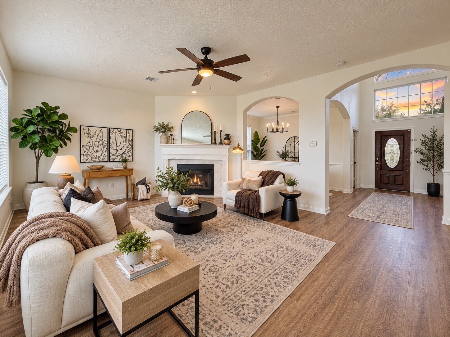 Spacious family room with elegant hardwood floors, a cozy fireplace, and abundant natural light, perfect for relaxing or entertaining.