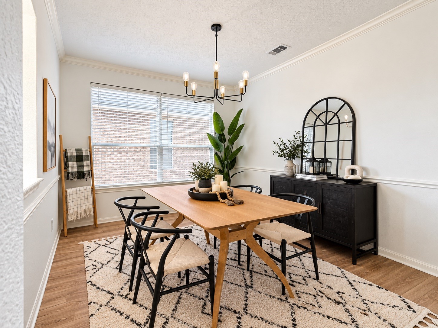 Elegant dining area with abundant natural light, stylish chandelier, and chic accents for a perfect gathering space.
