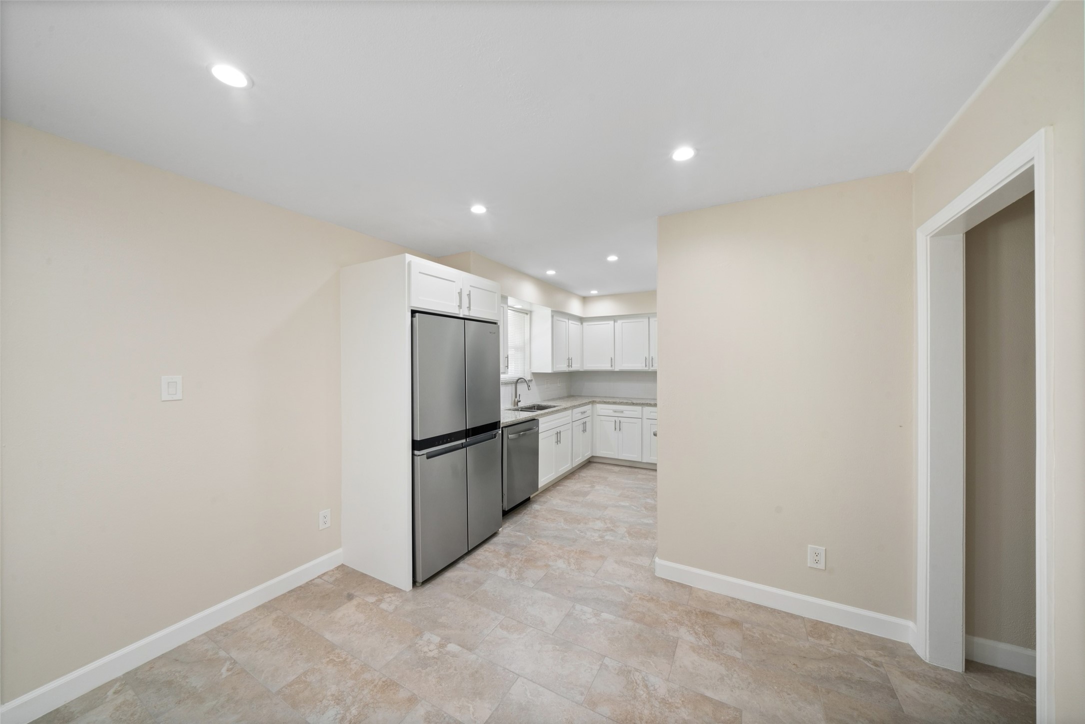 This beautifully remodeled kitchen features bright cabinetry, Dallas White granite countertops, and a clean, updated layout designed for both style and function.