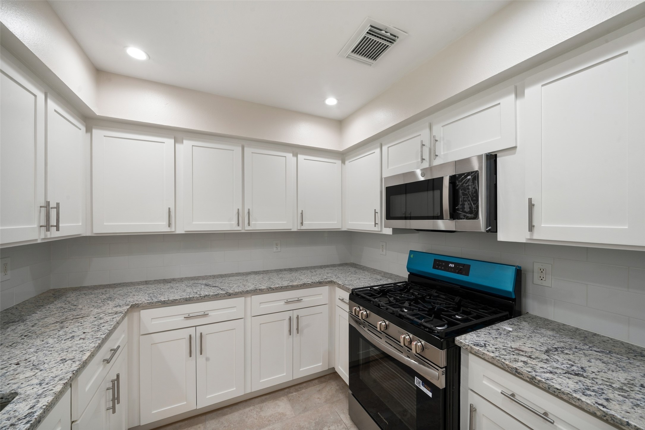 Upgrades include modified cabinets, a gas range, dishwasher, built-in microwave, double-deep sink, Moen brushed nickel faucet, and garbage disposal, creating a polished and practical space ready for everyday cooking and entertaining.