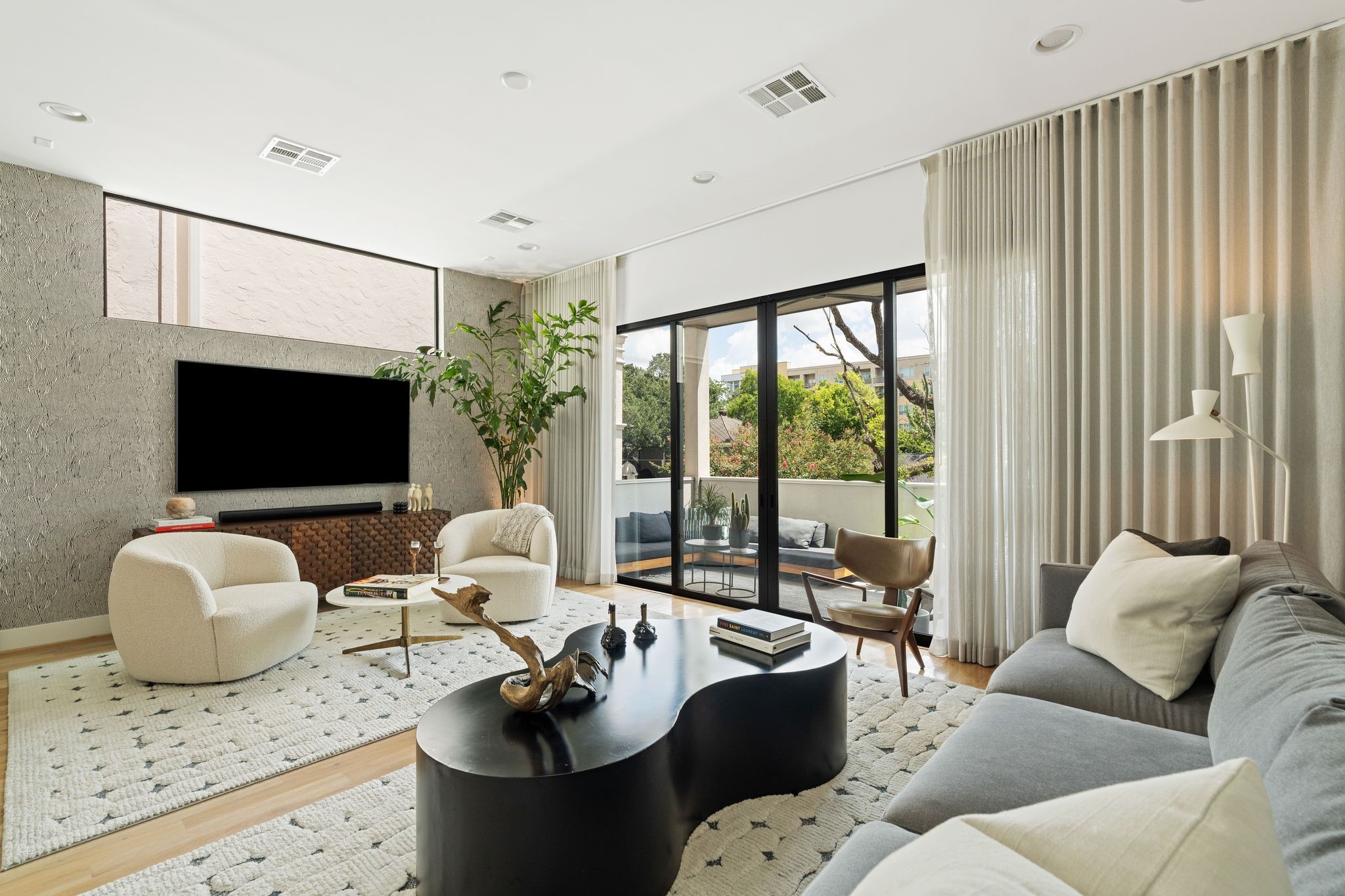 Another perspective of the expansive living room highlights abundant natural light and sliding glass doors opening directly to the covered terrace.