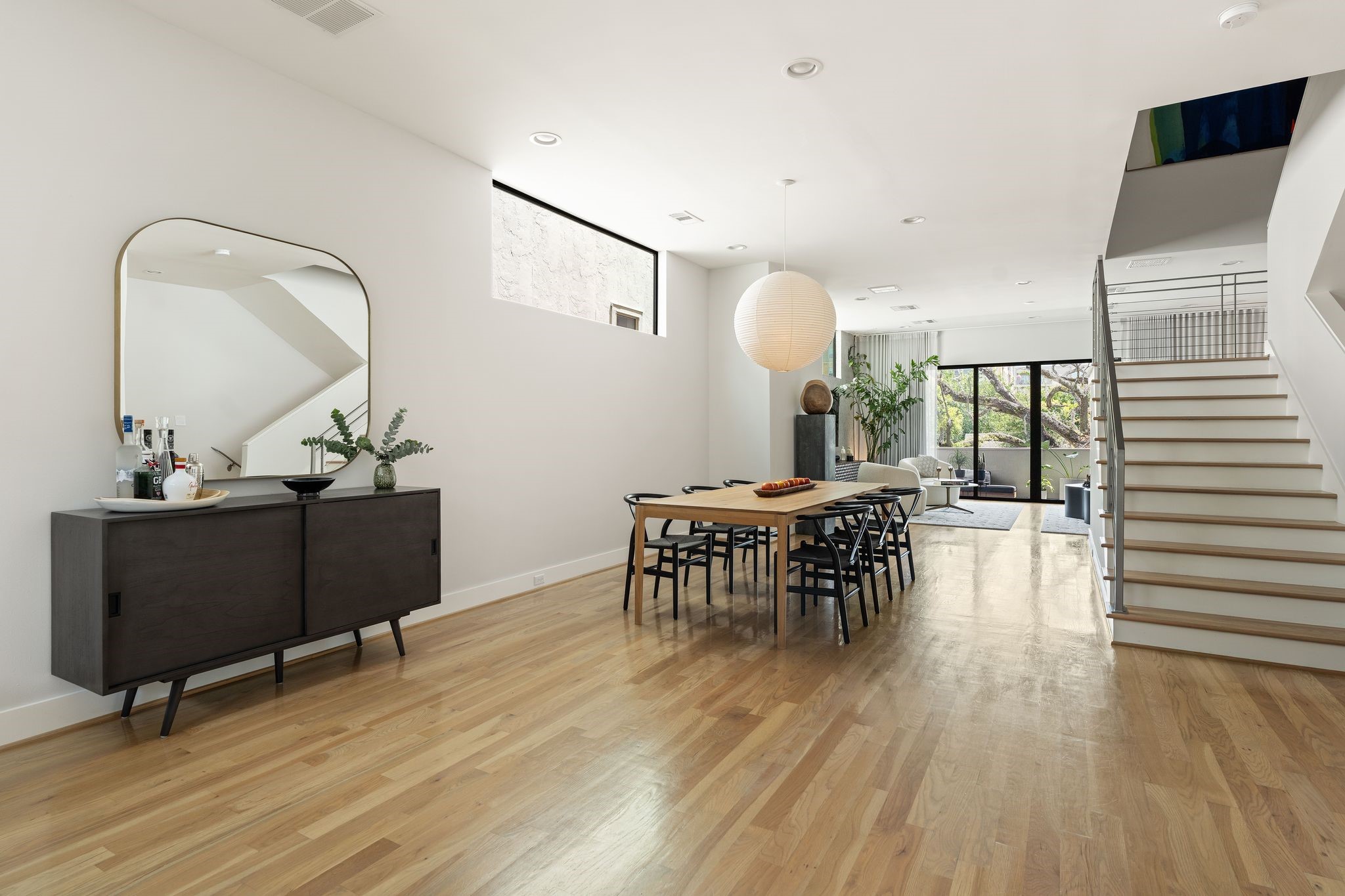 Spacious dining area with hardwood floors, excellent wall space, and convenient access to the third floor through the contemporary staircase.