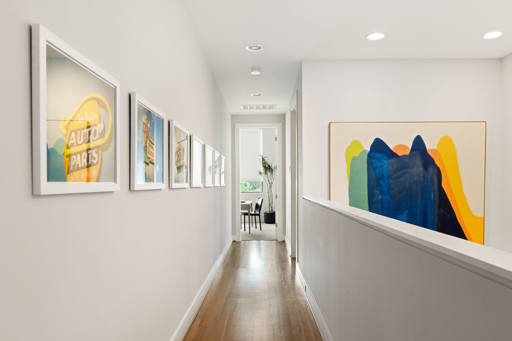 Architectural third-floor hallway connects the primary suite, secondary en suite bedroom, and conveniently located utility room while providing additional space to display art.