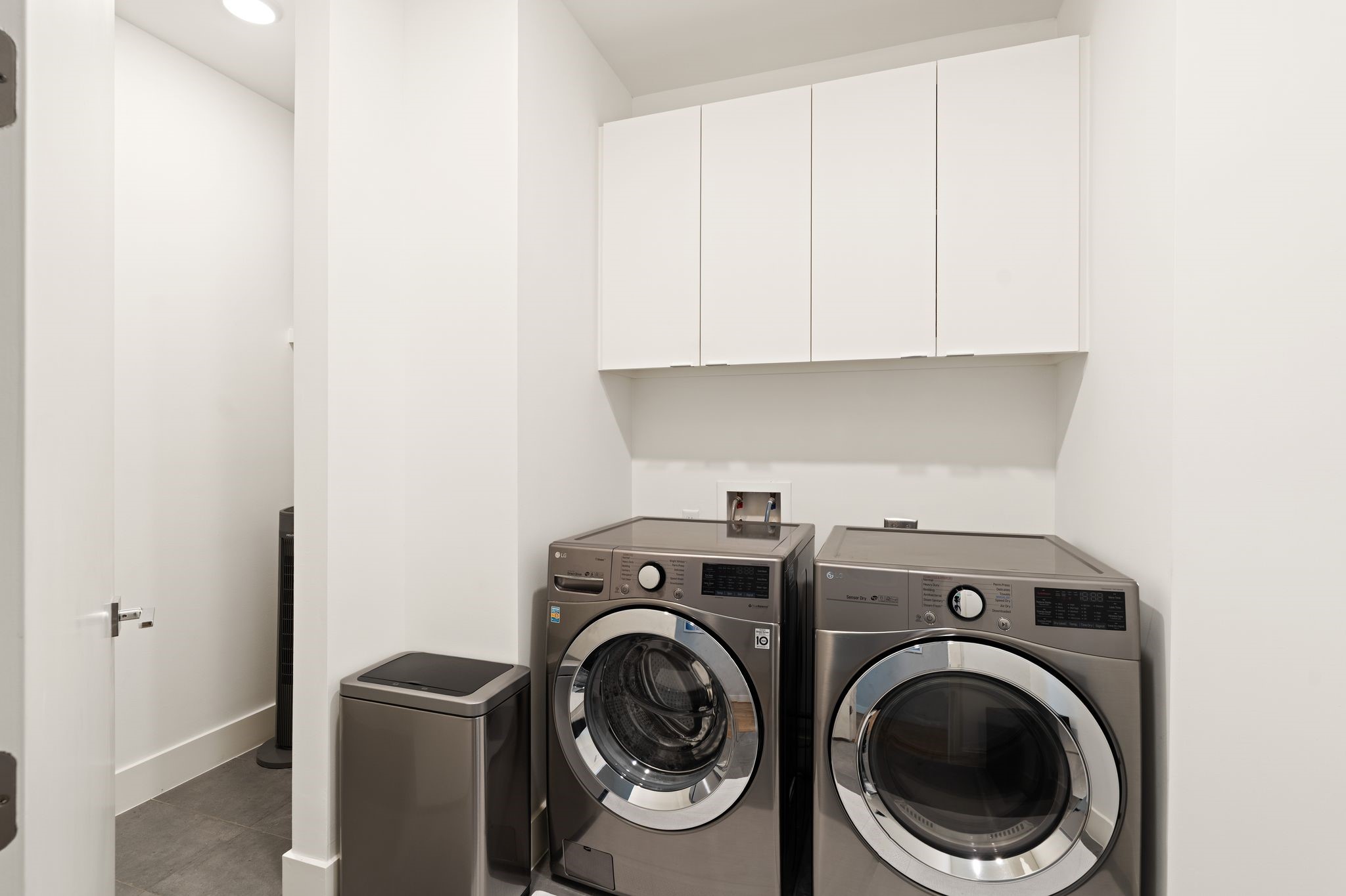 Spacious third-floor utility room offers full-size laundry, extensive built-in cabinetry, additional storage, and the homes central audio/visual equipment, supporting integrated technology and enhanced whole-home Wi-Fi coverage.