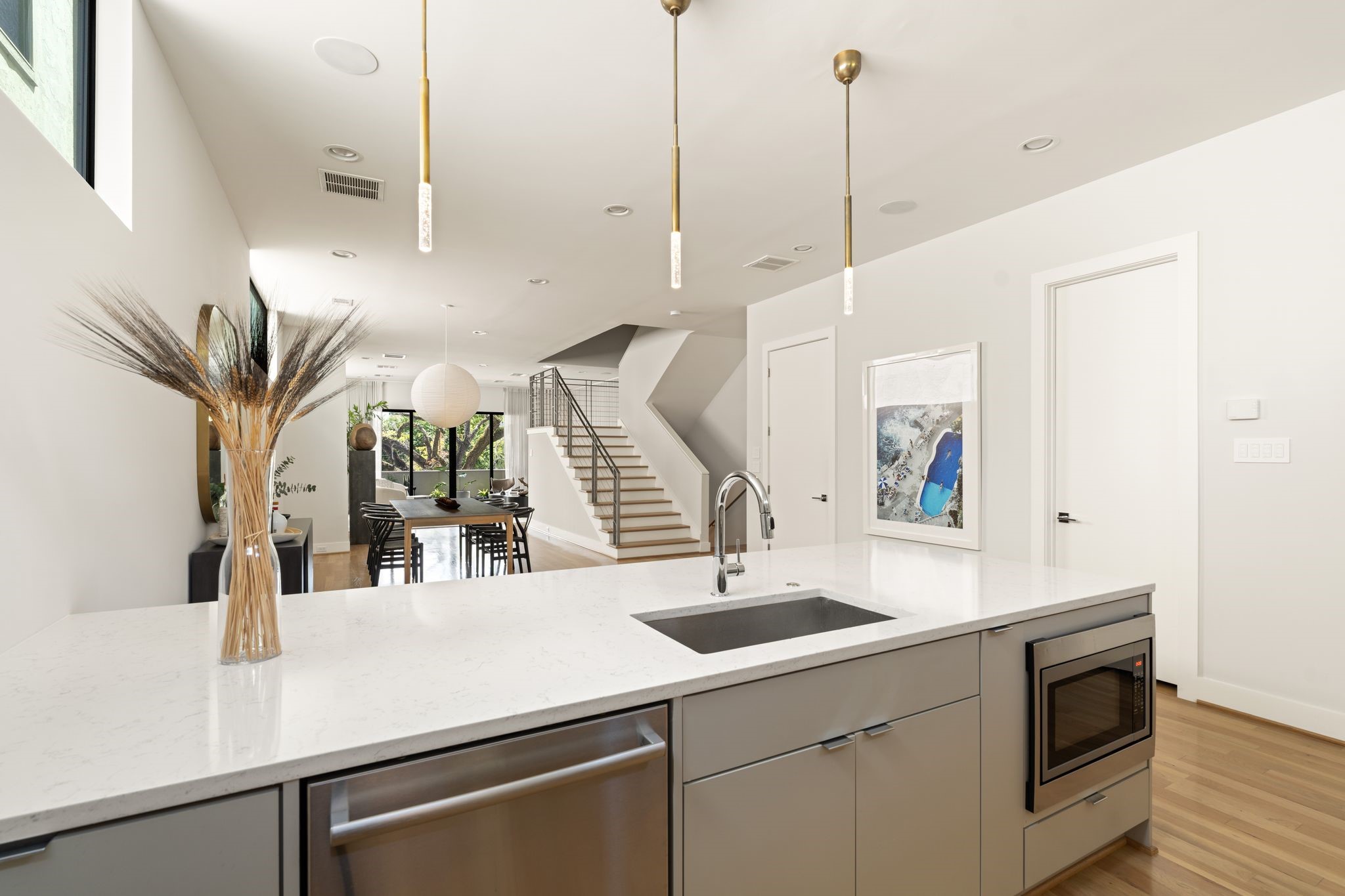 Generous kitchen peninsula incorporates the sink, dishwasher, microwave, and counter seating while maintaining an open connection to the dining and living areas.