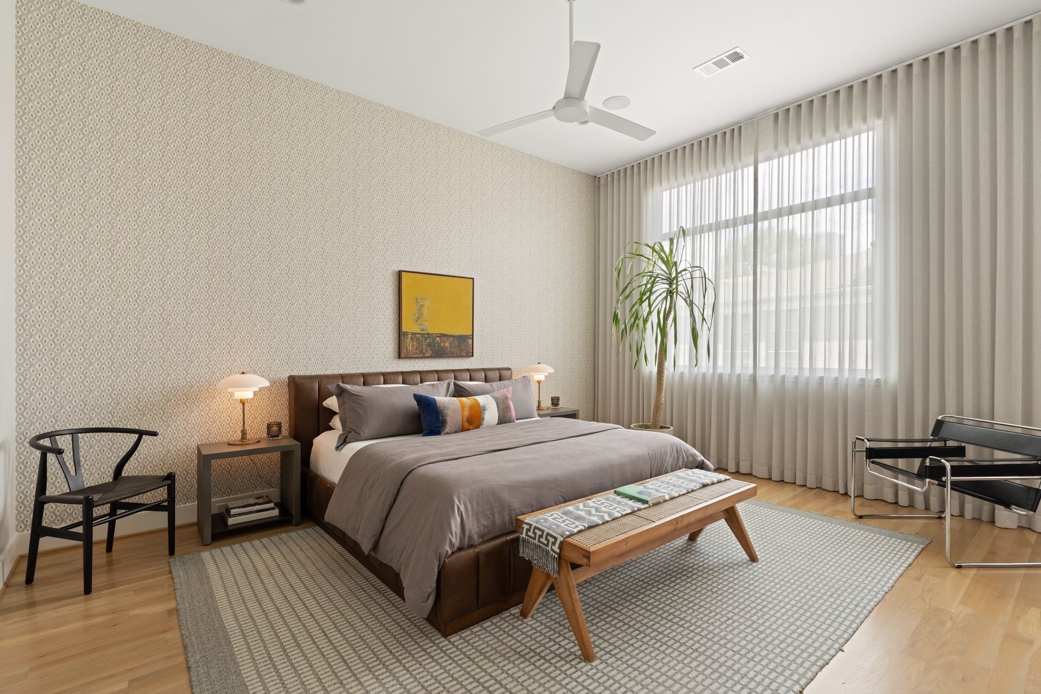 Chic primary suite with high ceilings, hardwood floors, abundant natural light, and motorized window shades for privacy and convenience. Chic primary suite with high ceilings, hardwood floors, abundant natural light, and motorized window shades for privacy and convenience.