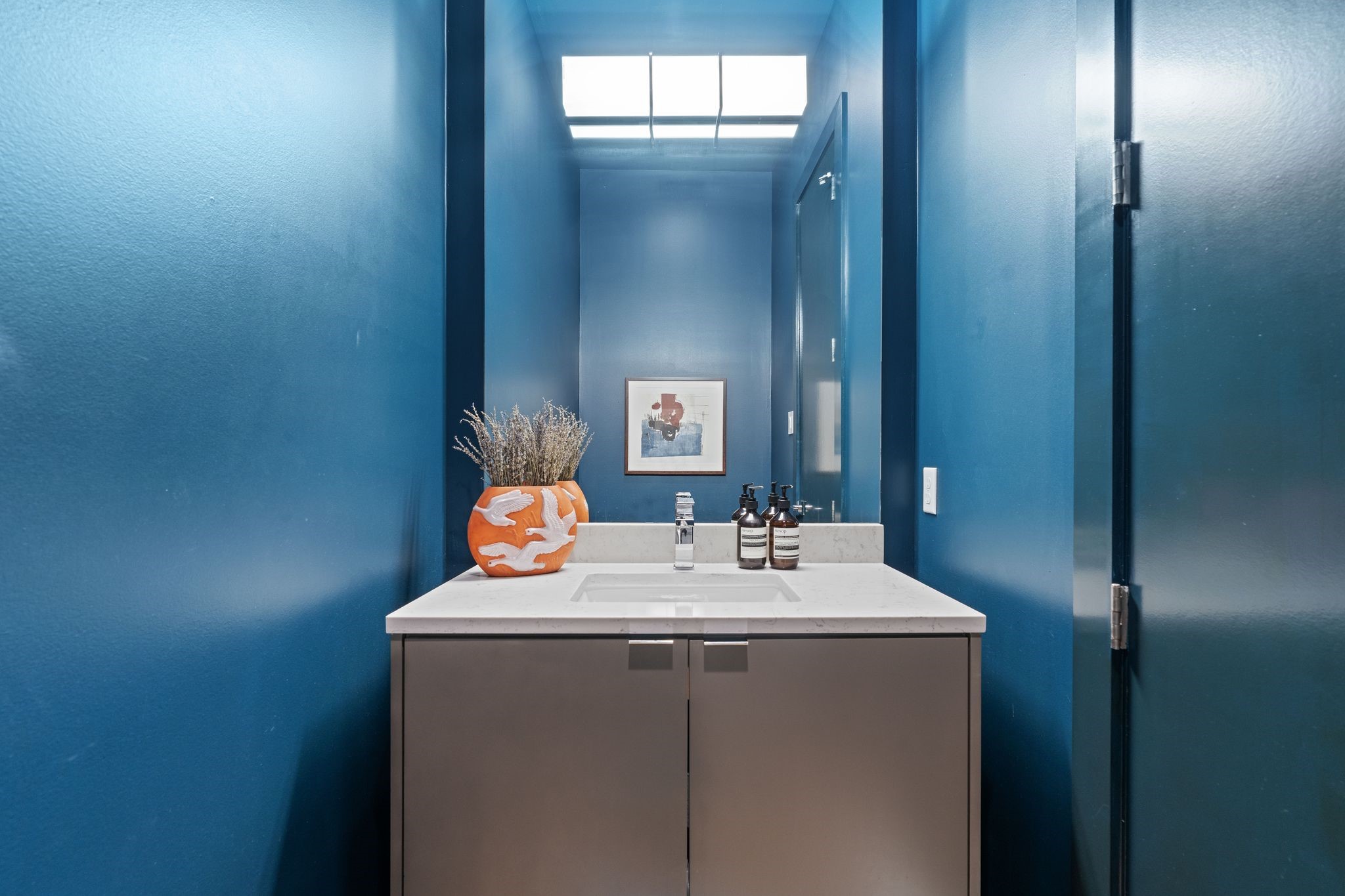 Stylish second-floor powder bath makes a statement with rich blue walls and provides convenient guest access from the main entertaining level.