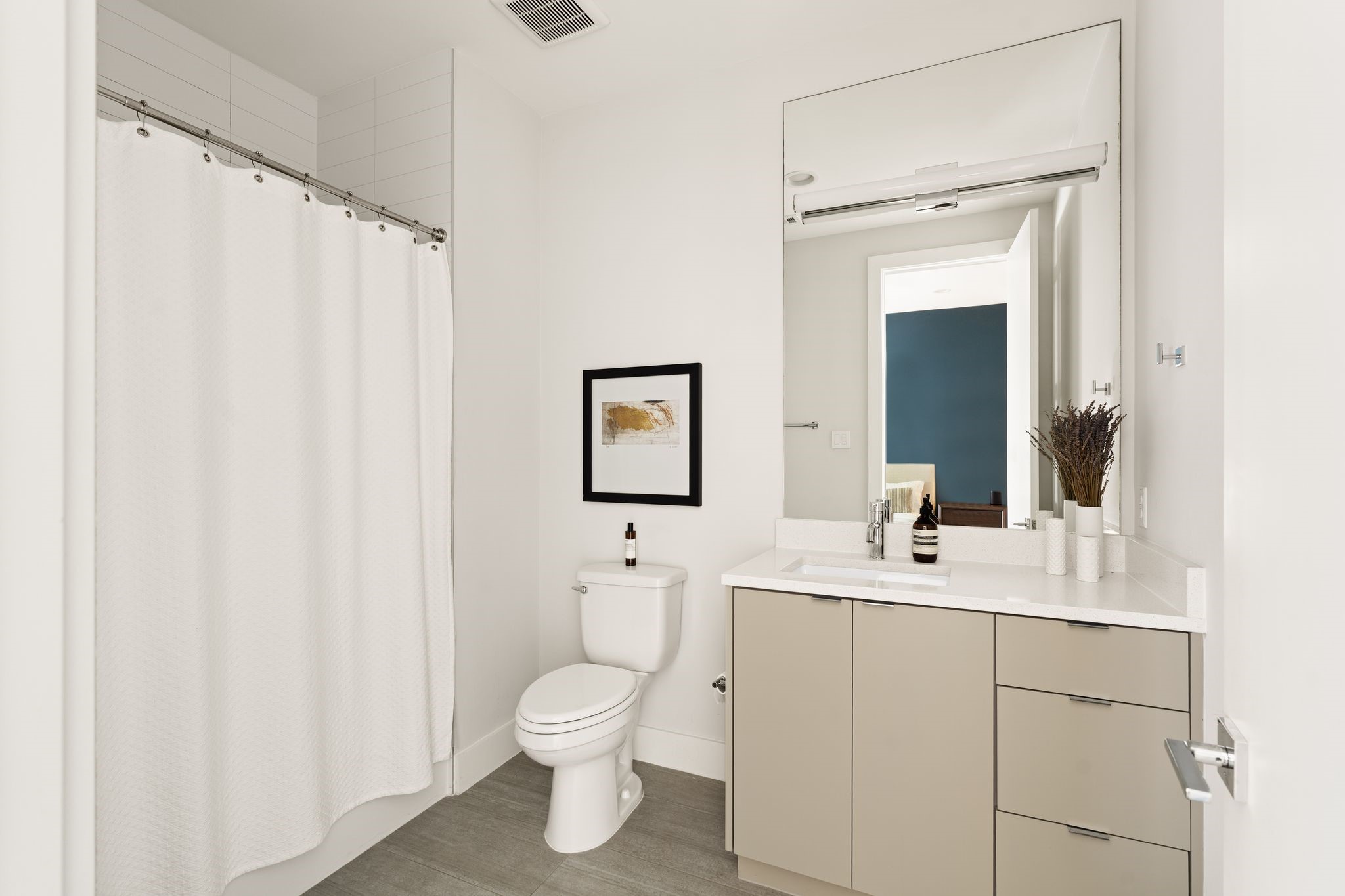 Private en suite bath serving the fourth bedroom features a tub-shower combination, contemporary finishes, and generous vanity storage.