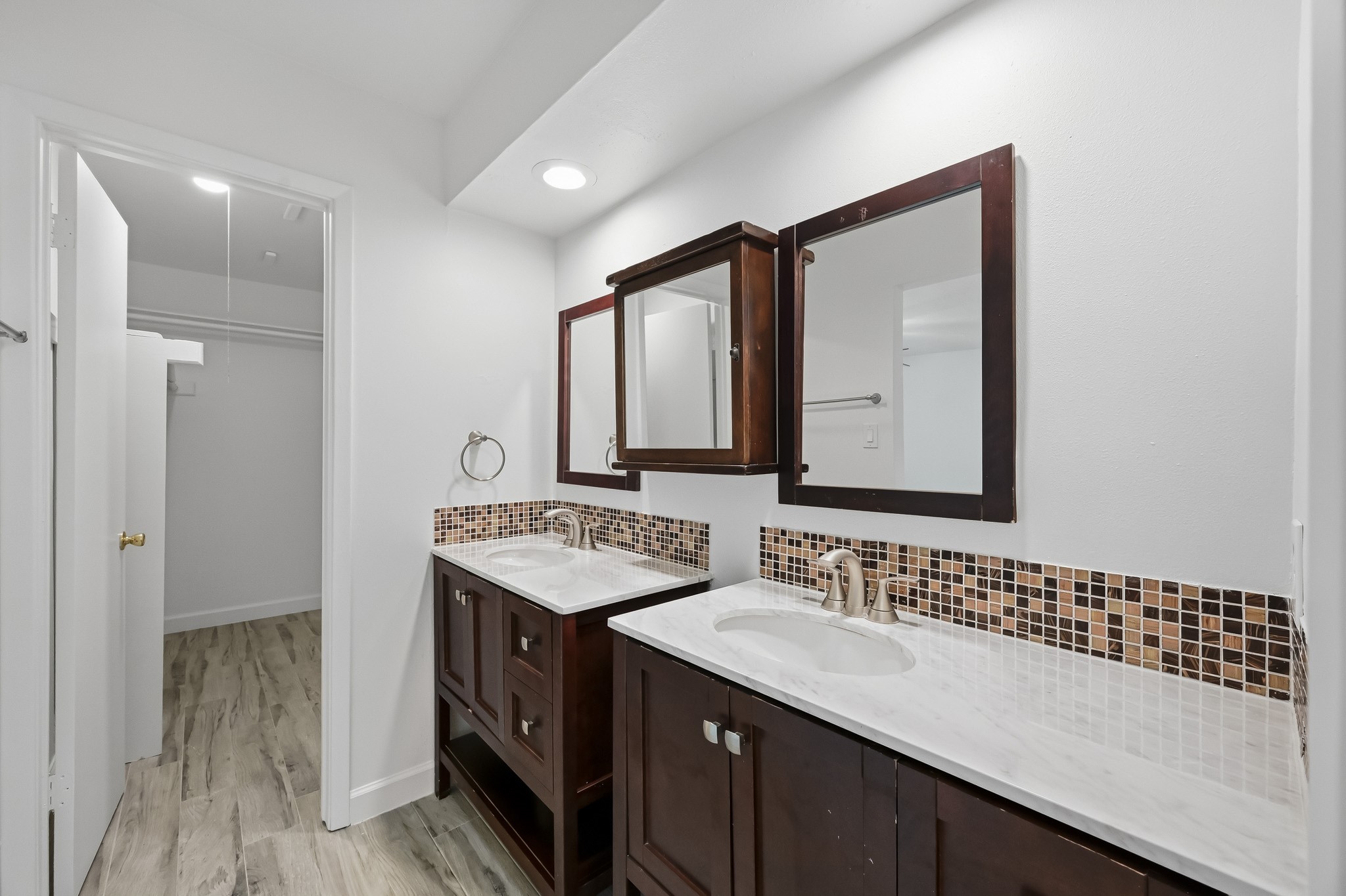 Designed for effortless morning routines, this spacious ensuite bath features two distinct vanity stations with substantial counter room and under-sink cabinetry, and flows smoothly into an expansive closet area.