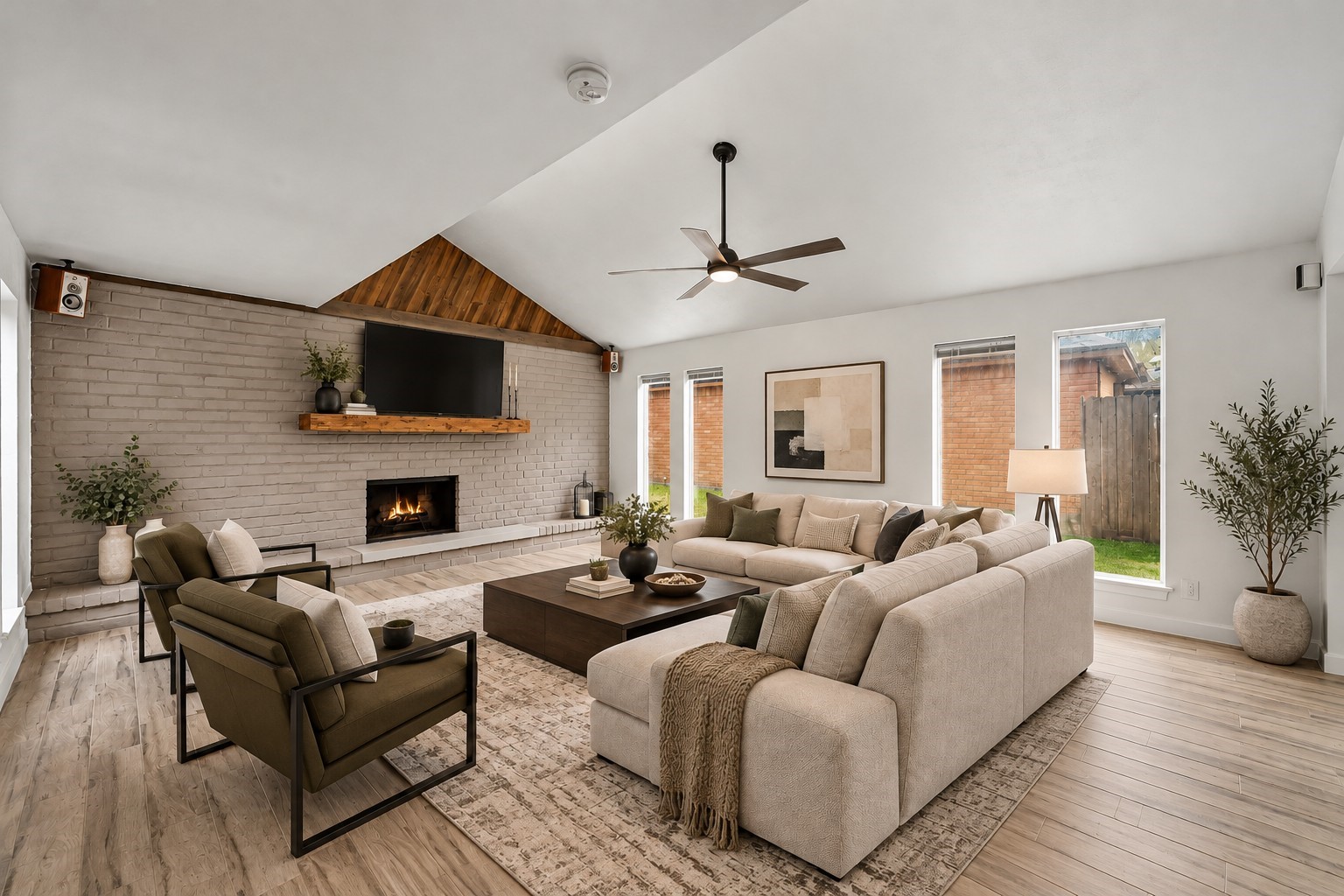 Virtually Staged: Soaring vaulted ceilings and an expansive layout make this living room the ultimate welcoming gathering space. A full-height brick accent wall anchors the room, complete with an extended hearth, a cozy fireplace. Virtually Staged: Soaring vaulted ceilings and an expansive layout make this living room the ultimate welcoming gathering space. A full-height brick accent wall anchors the room, complete with an extended hearth, a cozy fireplace.