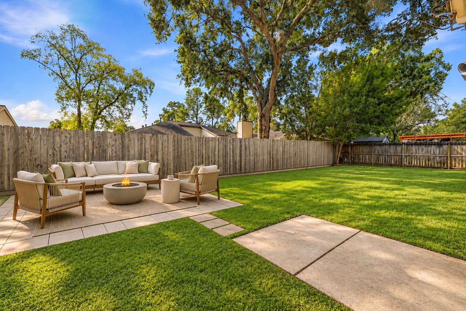 Virtually Staged: A paved patio zone provides a dedicated open-air lounge around a glowing central fire bowl, linked by stepping stones to adjacent hardscape pads.