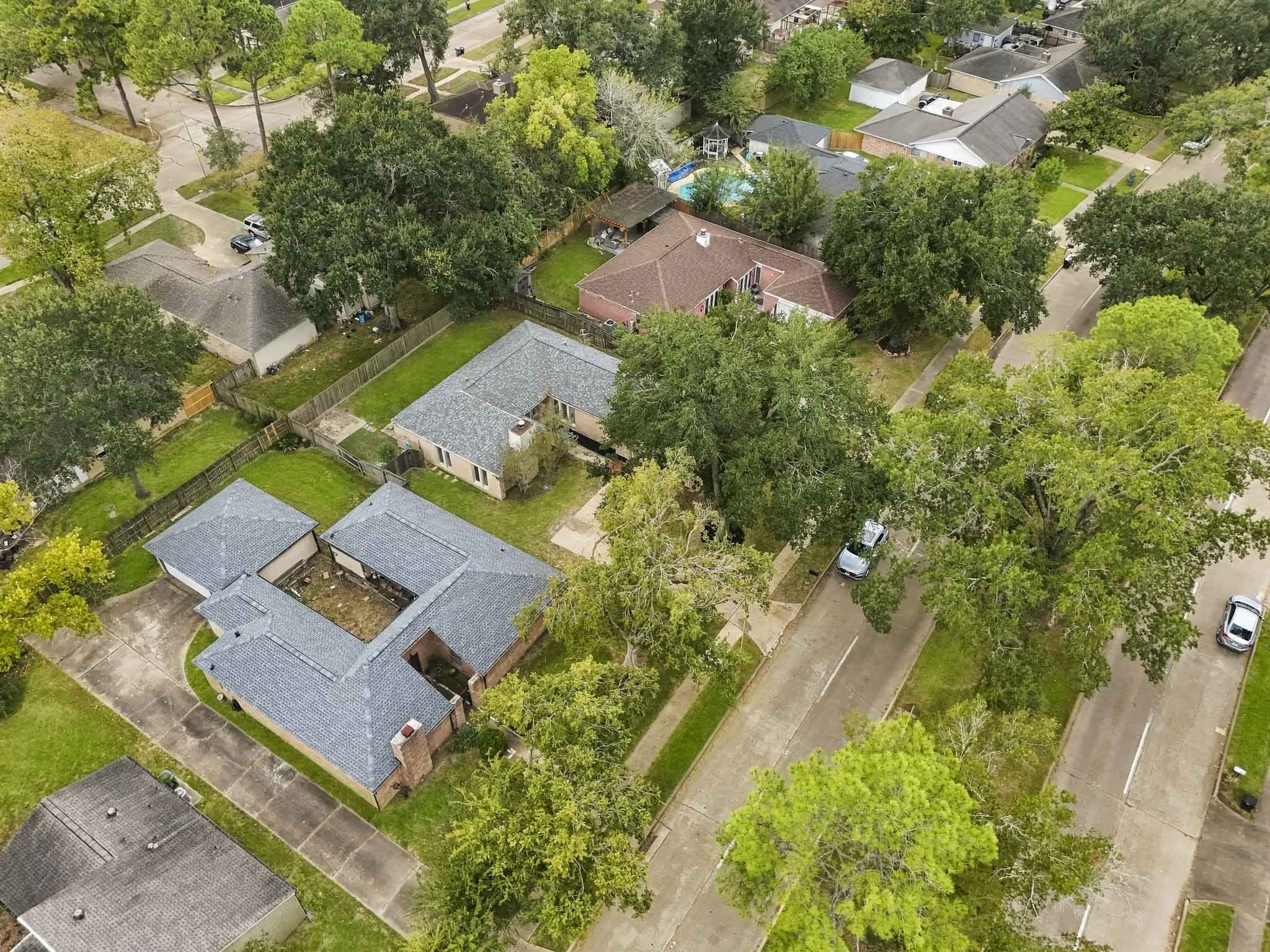 Viewed from above, the property stands out for its generous acreage, lush surroundings, and unique single-level configuration.