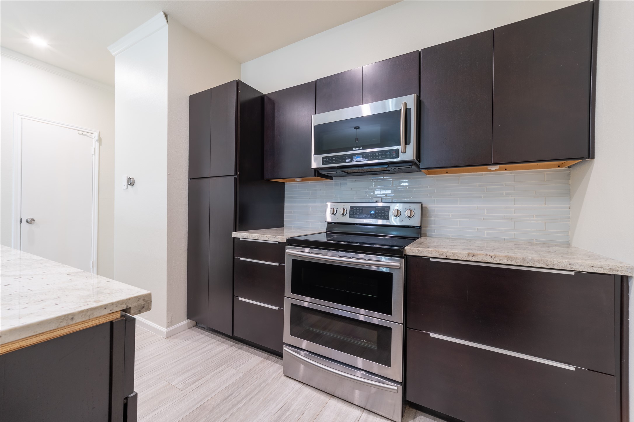 Modern kitchen with stainless steel appliances, quartz countertops, and soft close cabinetry