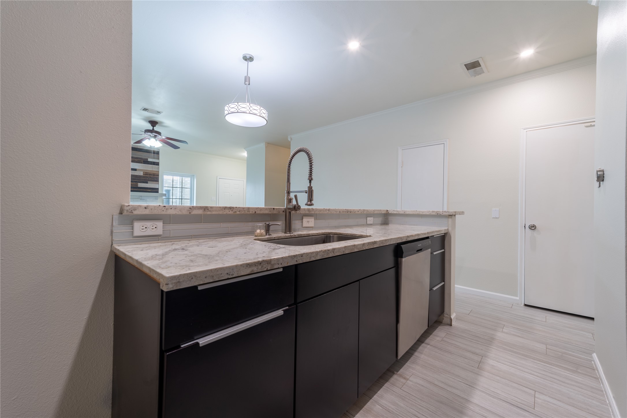 Kitchen Peninsula with a farmhouse sink, quartz countertops and stainless steel dishwasher