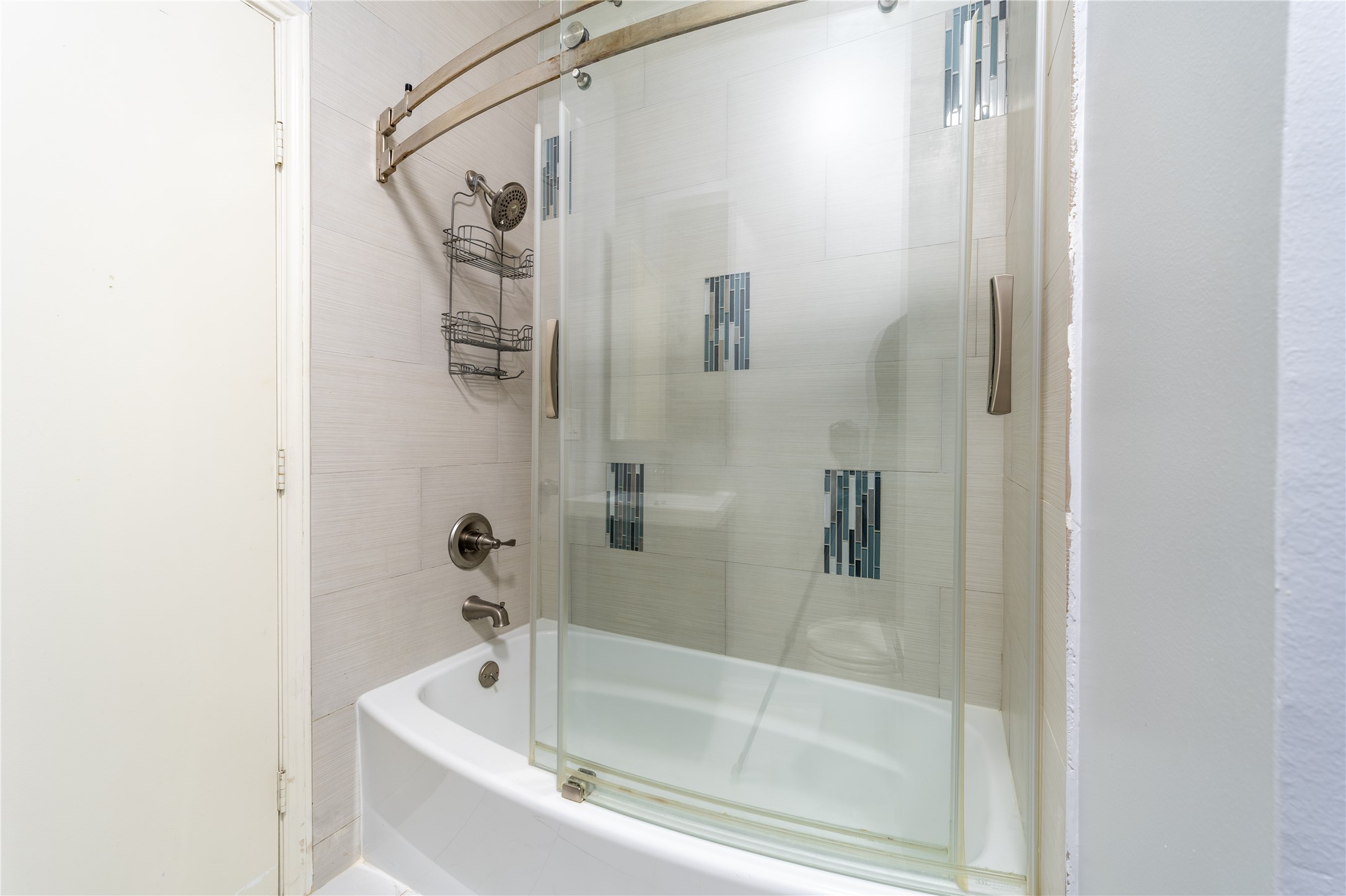 Updated bathroom with a glass-enclosed tub and shower