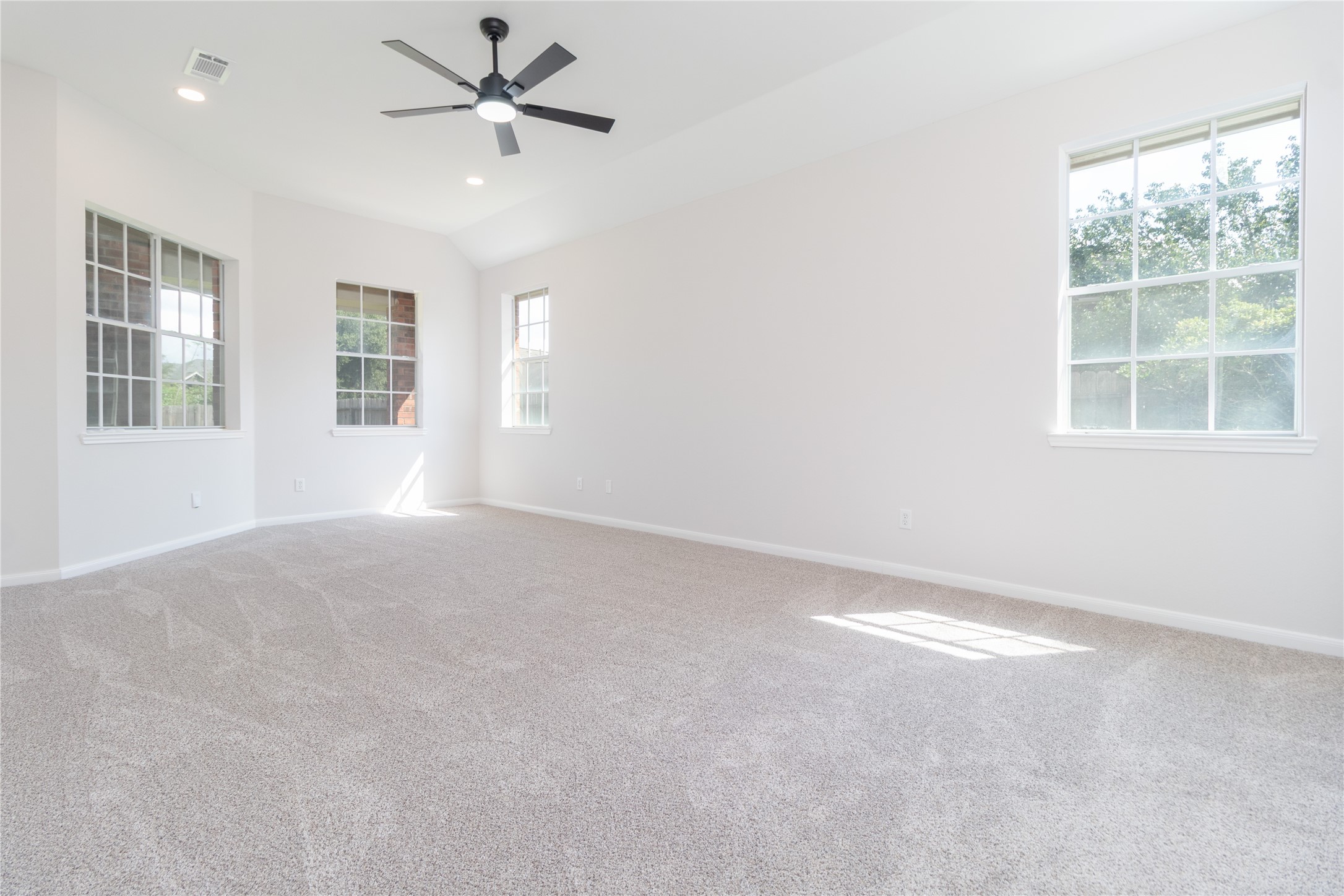 Primary bedroom. High ceiling, recessed lighting, and new carpet. Primary bedroom. High ceiling, recessed lighting, and new carpet.