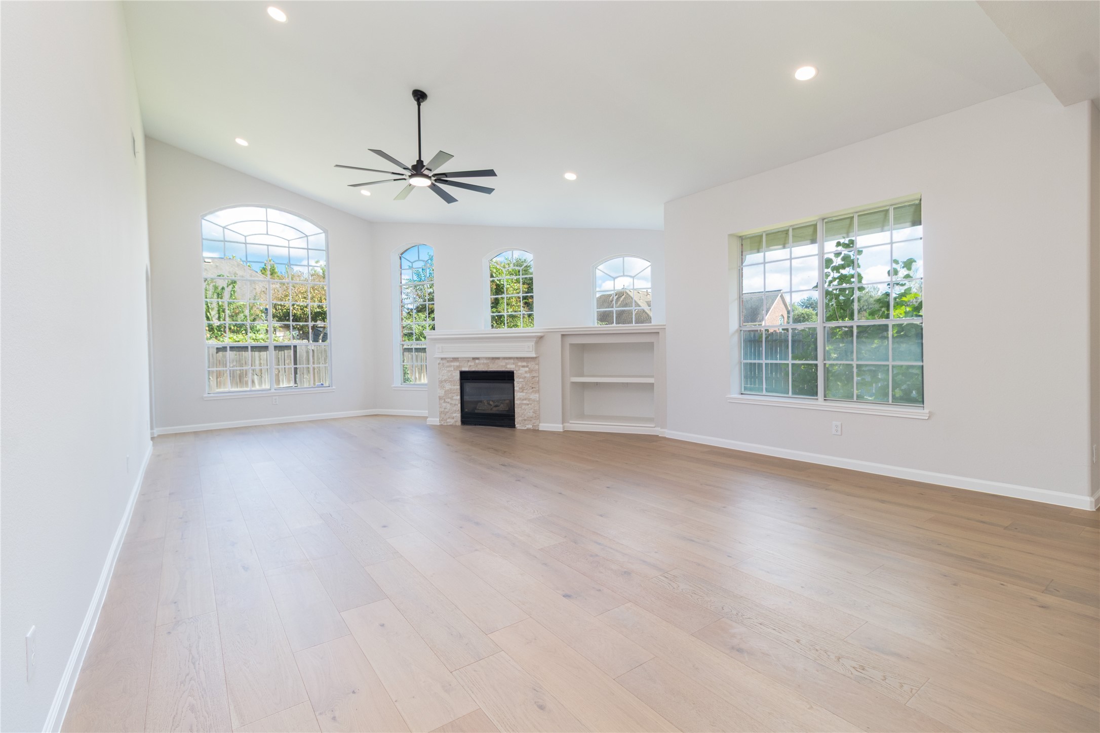 View of the living room from the kitchen area. Several windows provide beauty and natural light.