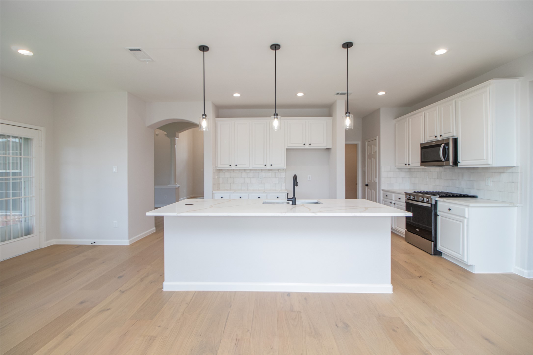Updated and redesigned kitchen with new quartz countertops, backsplash, SS appliances, recessed lights, fixtures, and more.