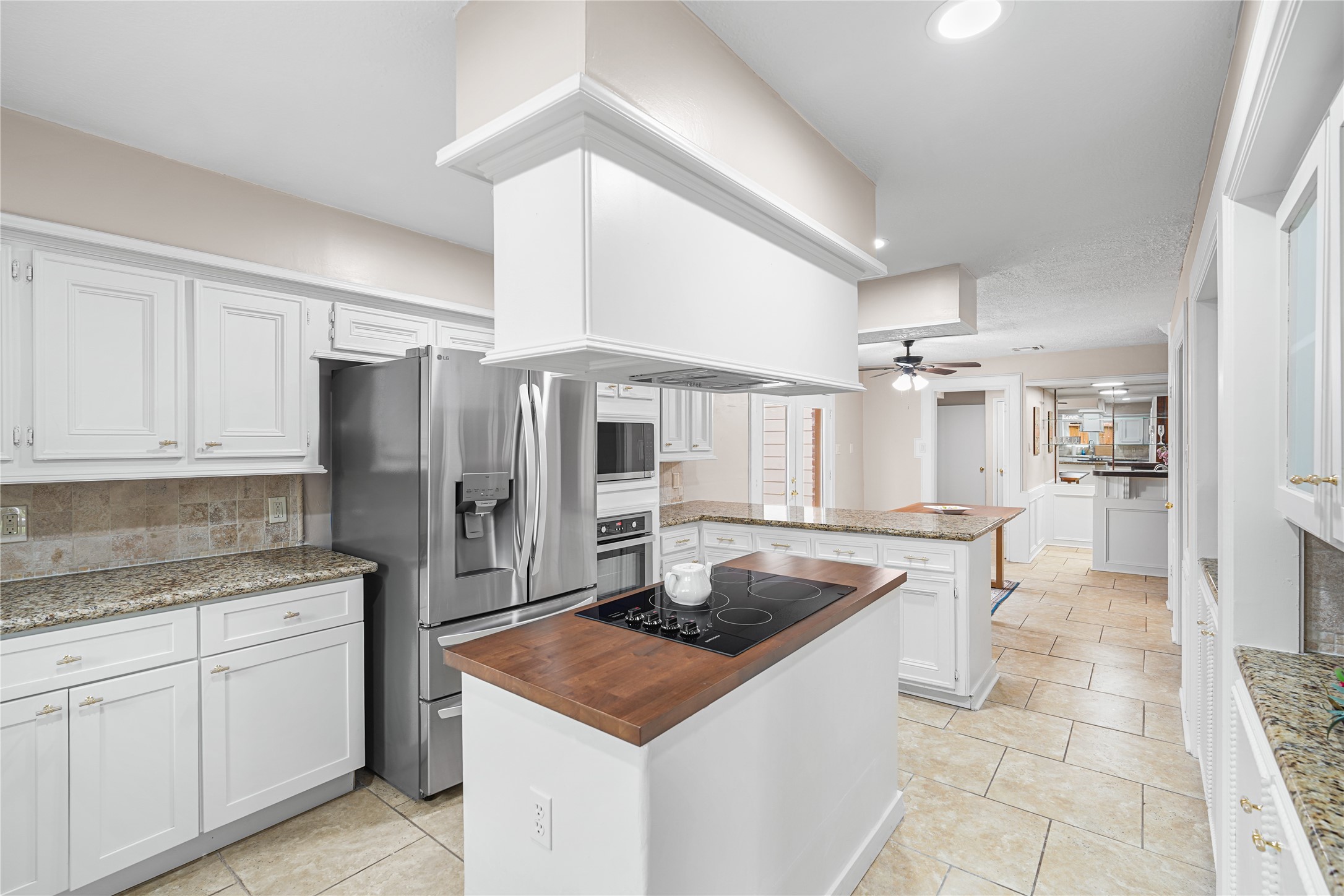 A central island with a cooktop, all set against elegant tile flooring.