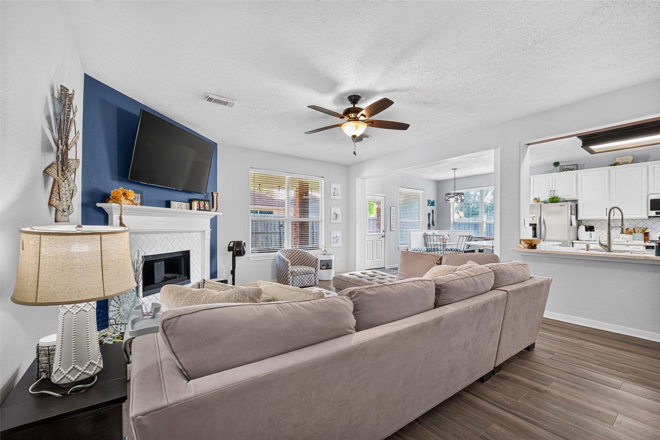 Sunlit living room with sightlines into the kitchen and dining areas.