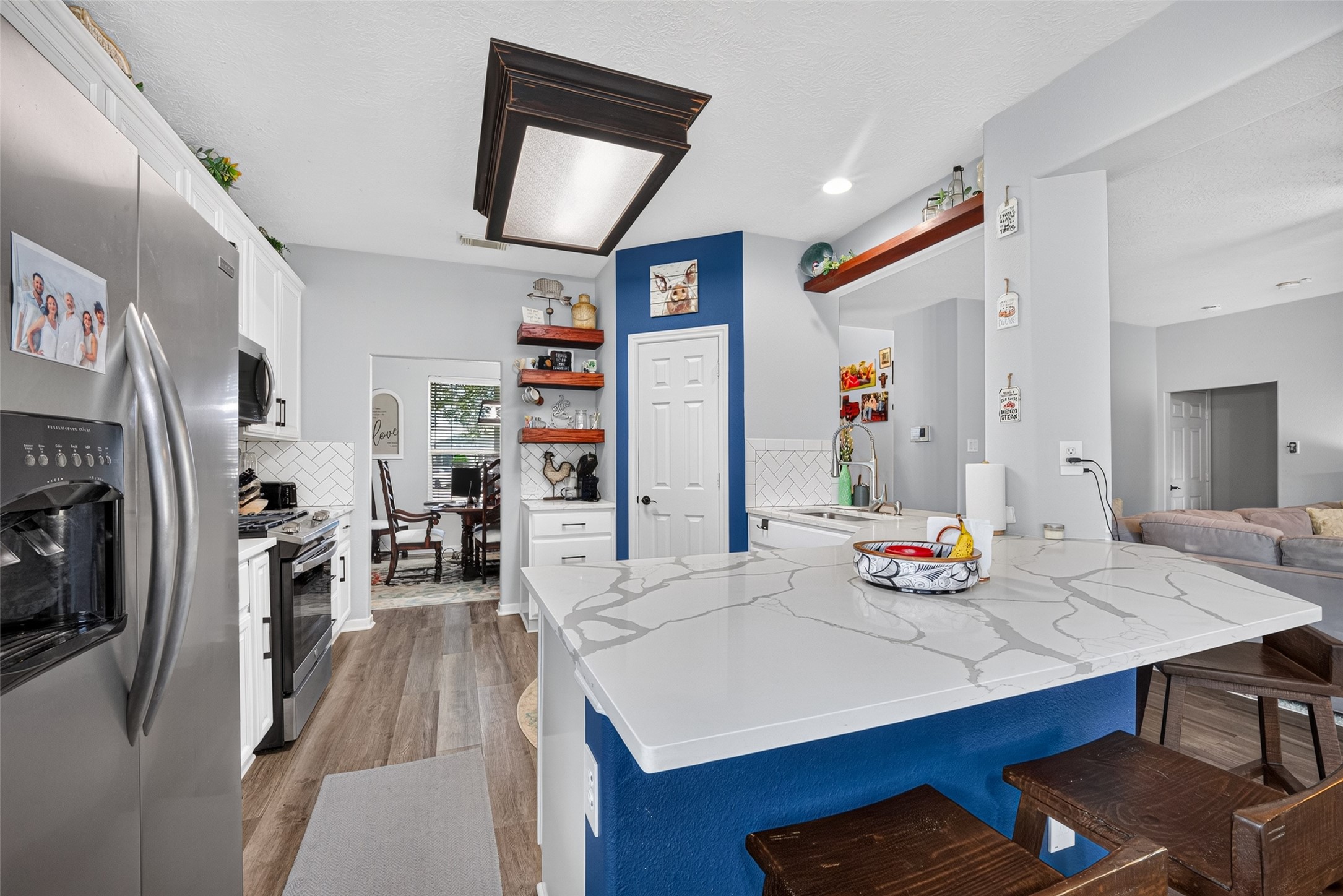 Island kitchen with bar seating, open to the living room.
