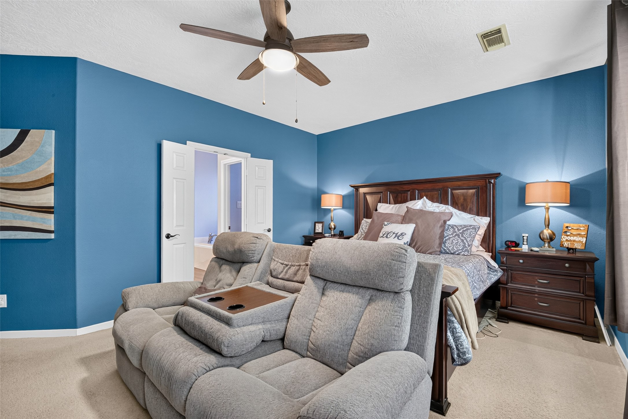 Primary bedroom with accent wall and plenty of daylight.