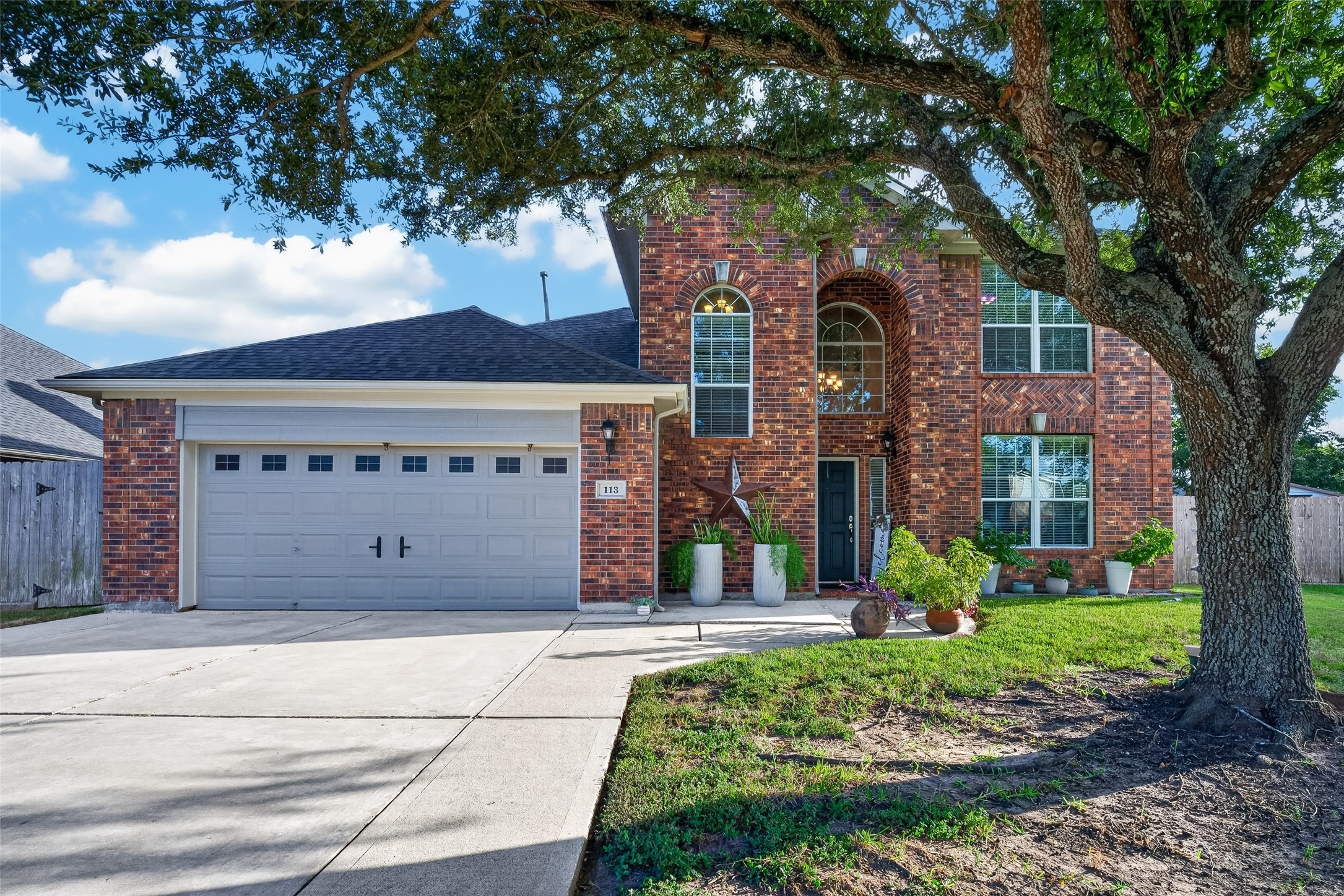 Charming front exterior with manicured lawn and mature landscaping.