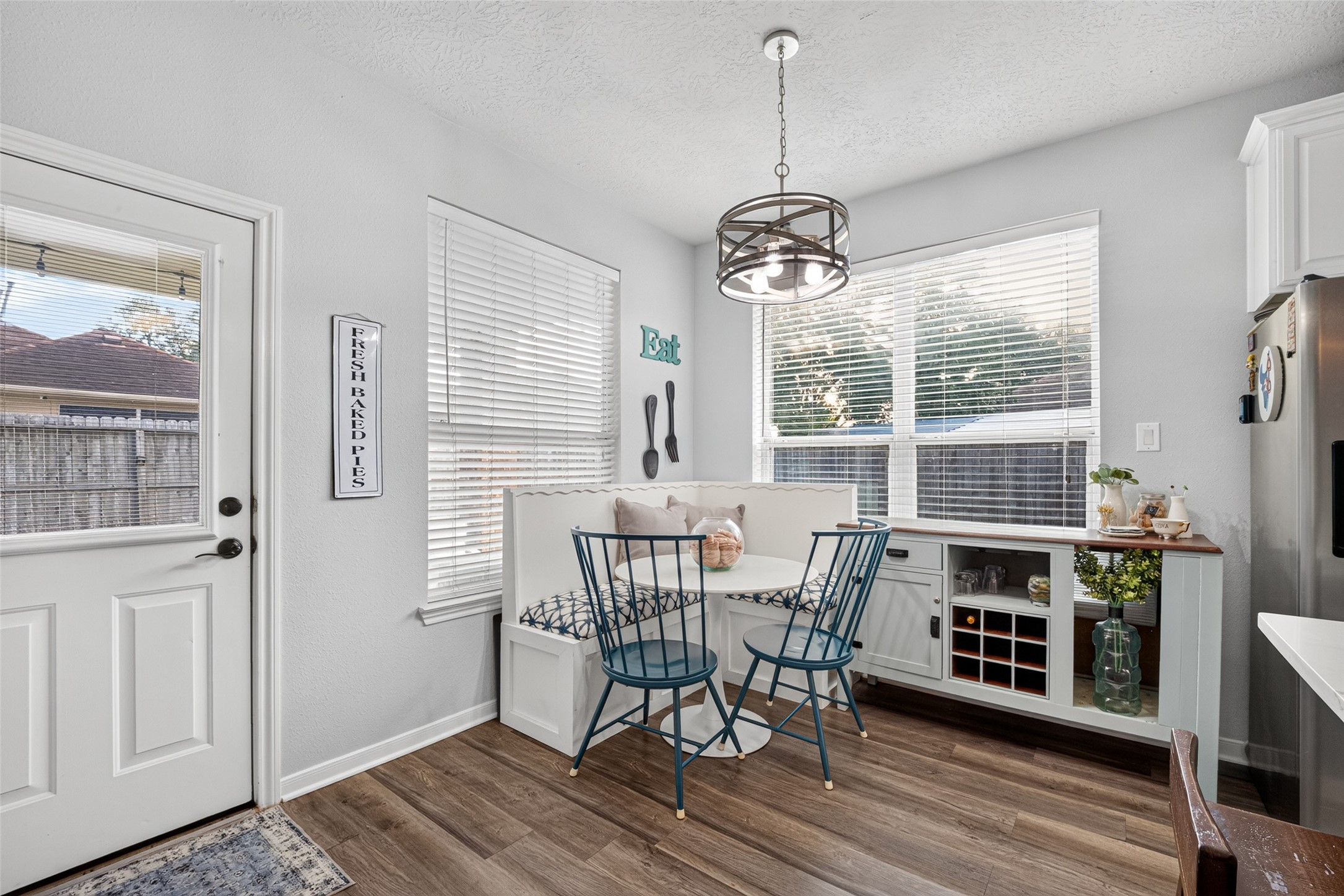 Dining area washed in natural light from oversized windows.