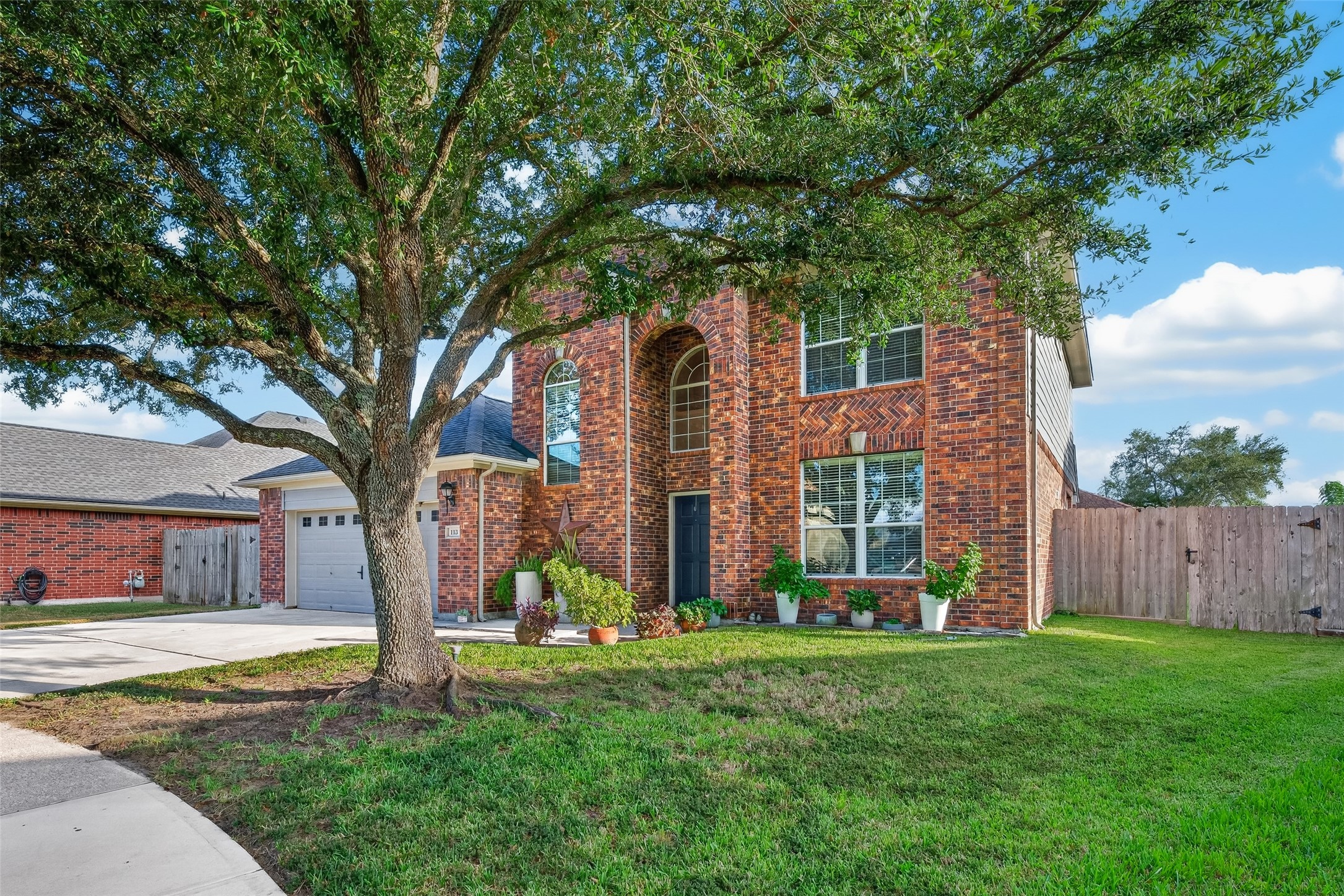 Front view framed by a grand shade tree. Front view framed by a grand shade tree.