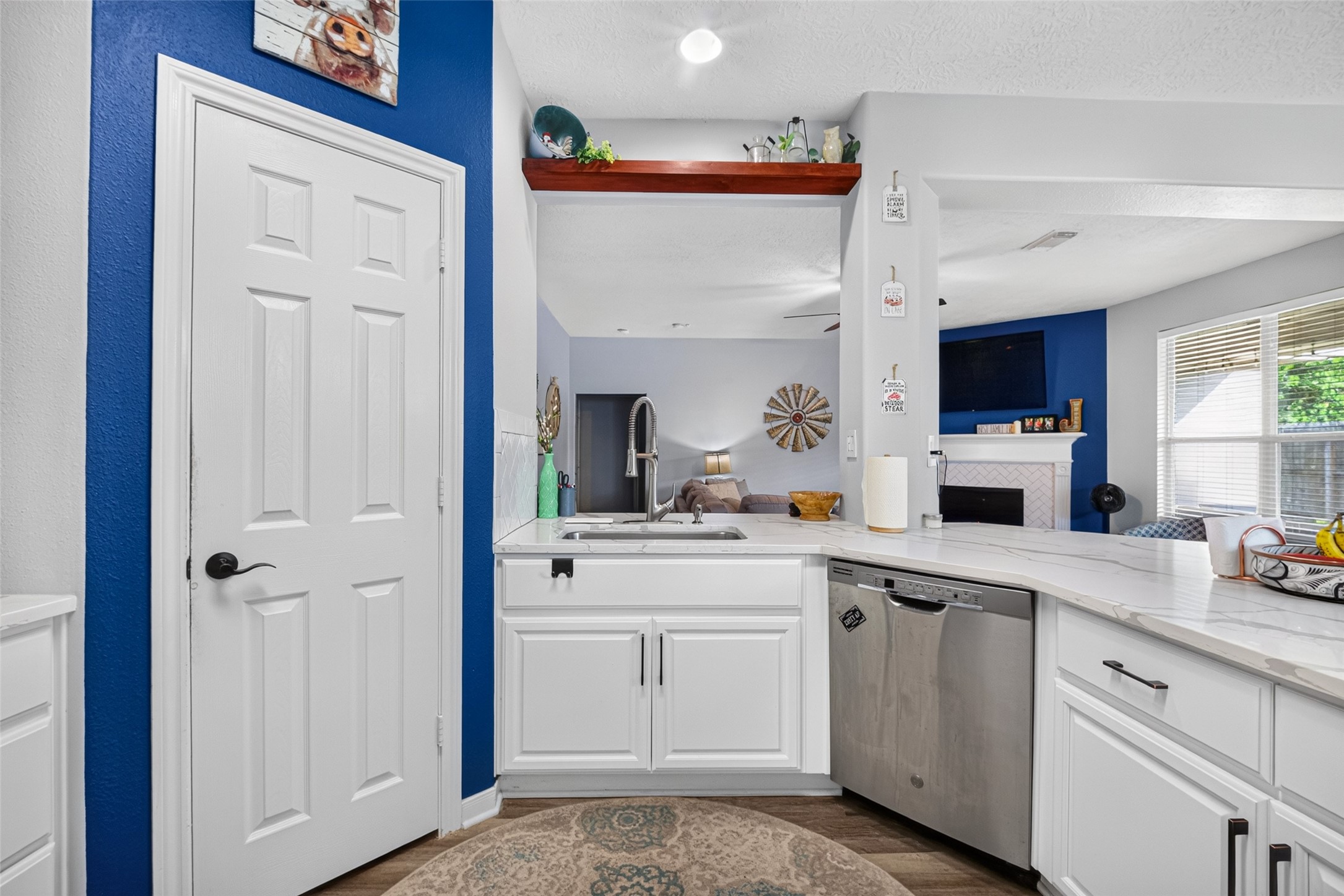 Cheerful kitchen nook with a blue accent wall and garden-window sink.
