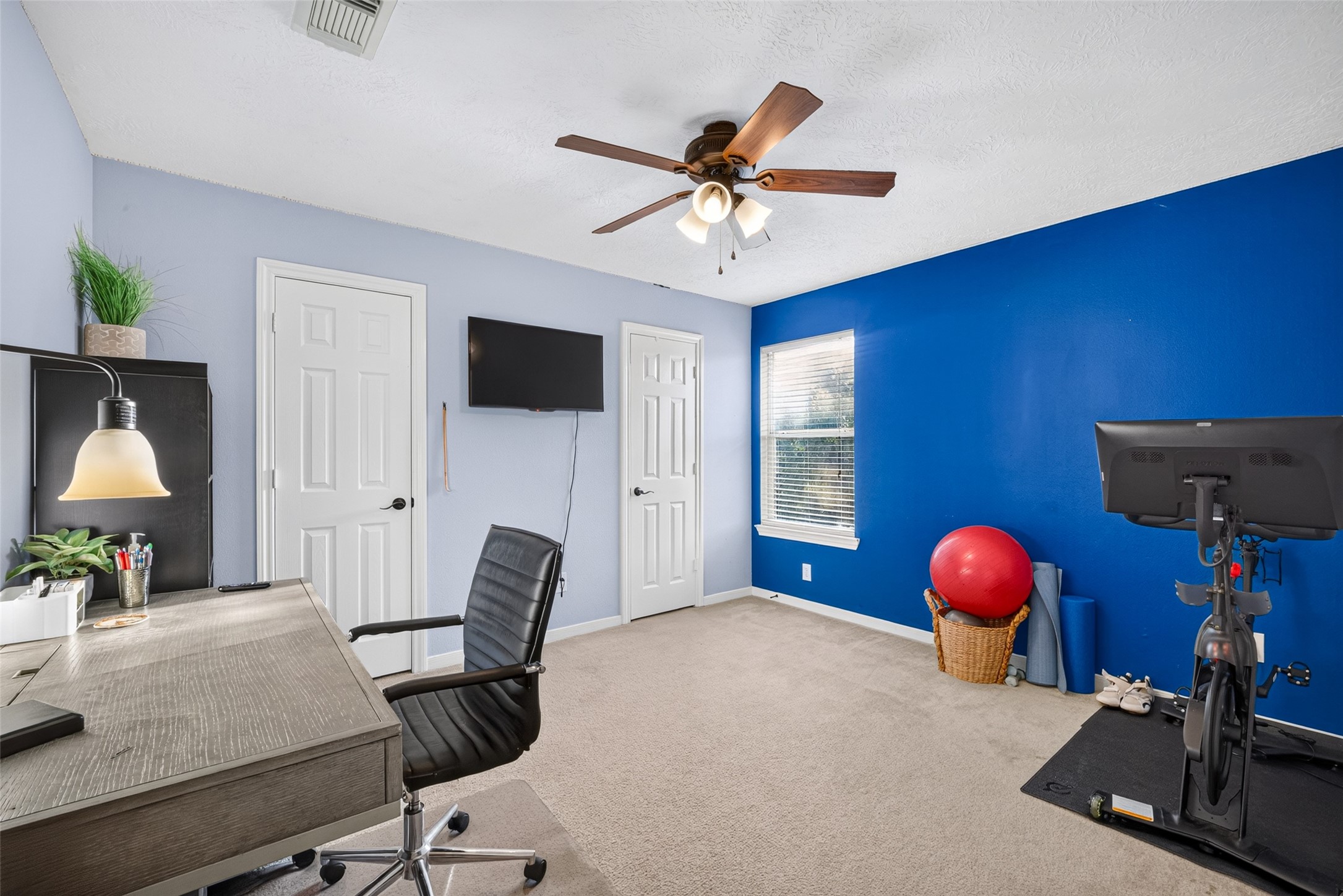 Home office with a bold blue accent wall  work from home in style.