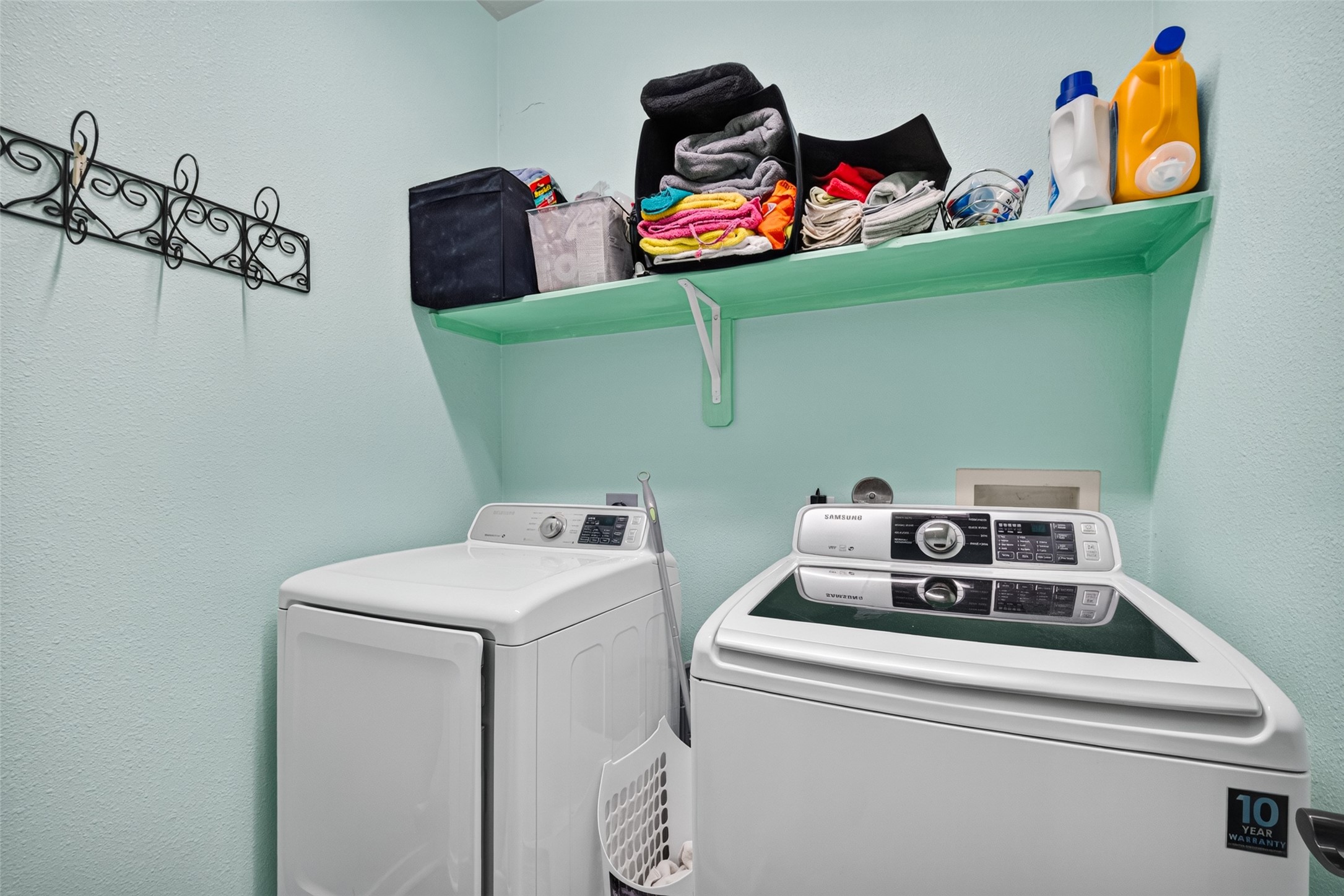 Indoor laundry room with built-in storage shelving.